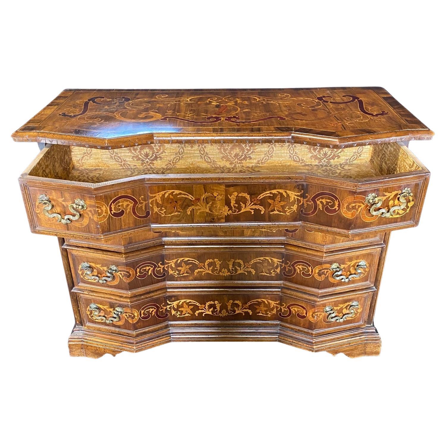 An exceptional quality antique chest of drawers finely hand crafted in Italy in the 19th century, featuring an intricately inlaid top, drawers and sides with birds and dancing figures beautifully framed with leaves and garlands. Lovely serpentine