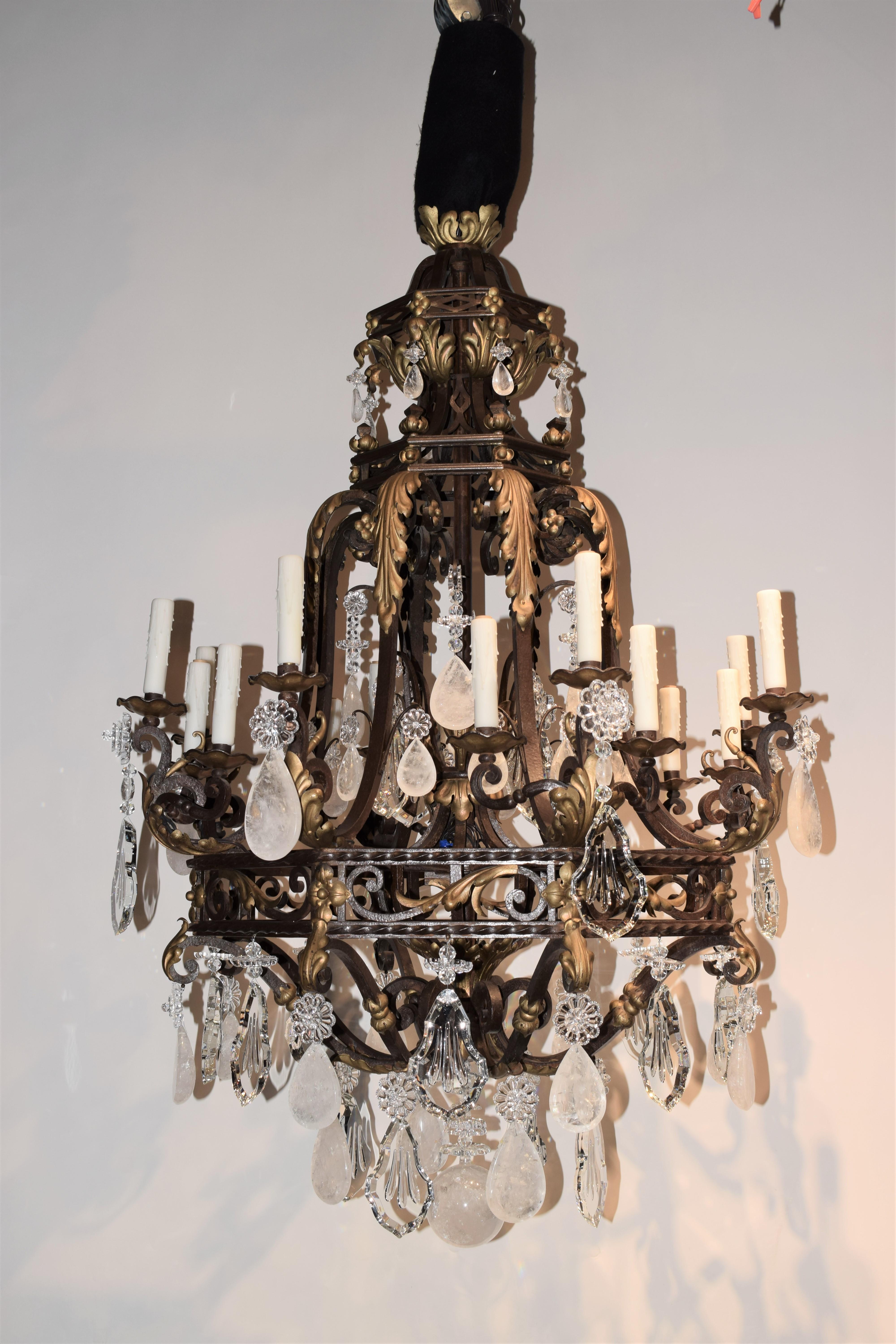 A Magnificent Hand Hammered iron chandelier. Gilt Reposse. Acanthus leaves throughout. Crystal & Rock Crystal Pendalogues. France, circa 1890. 16 lights. 
Dimensions: Height 57