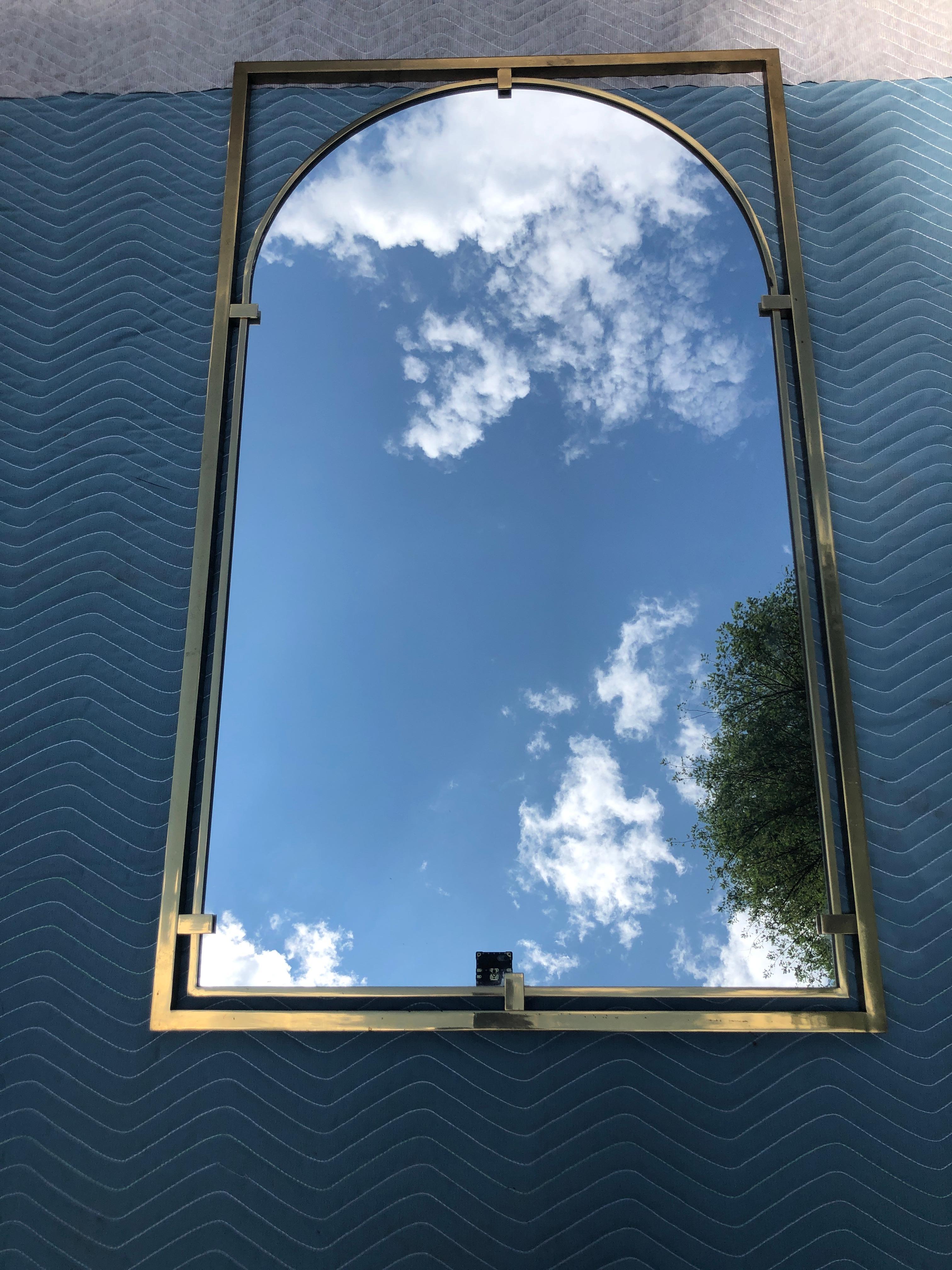  Dramatic and Substantial Solid Brass Mirror with modernist Curved Arch Set in a Floating Rectangular Frame Designed By John Widdicomb in The 1960's. This piece measures 47” t x 28” w x 2” d