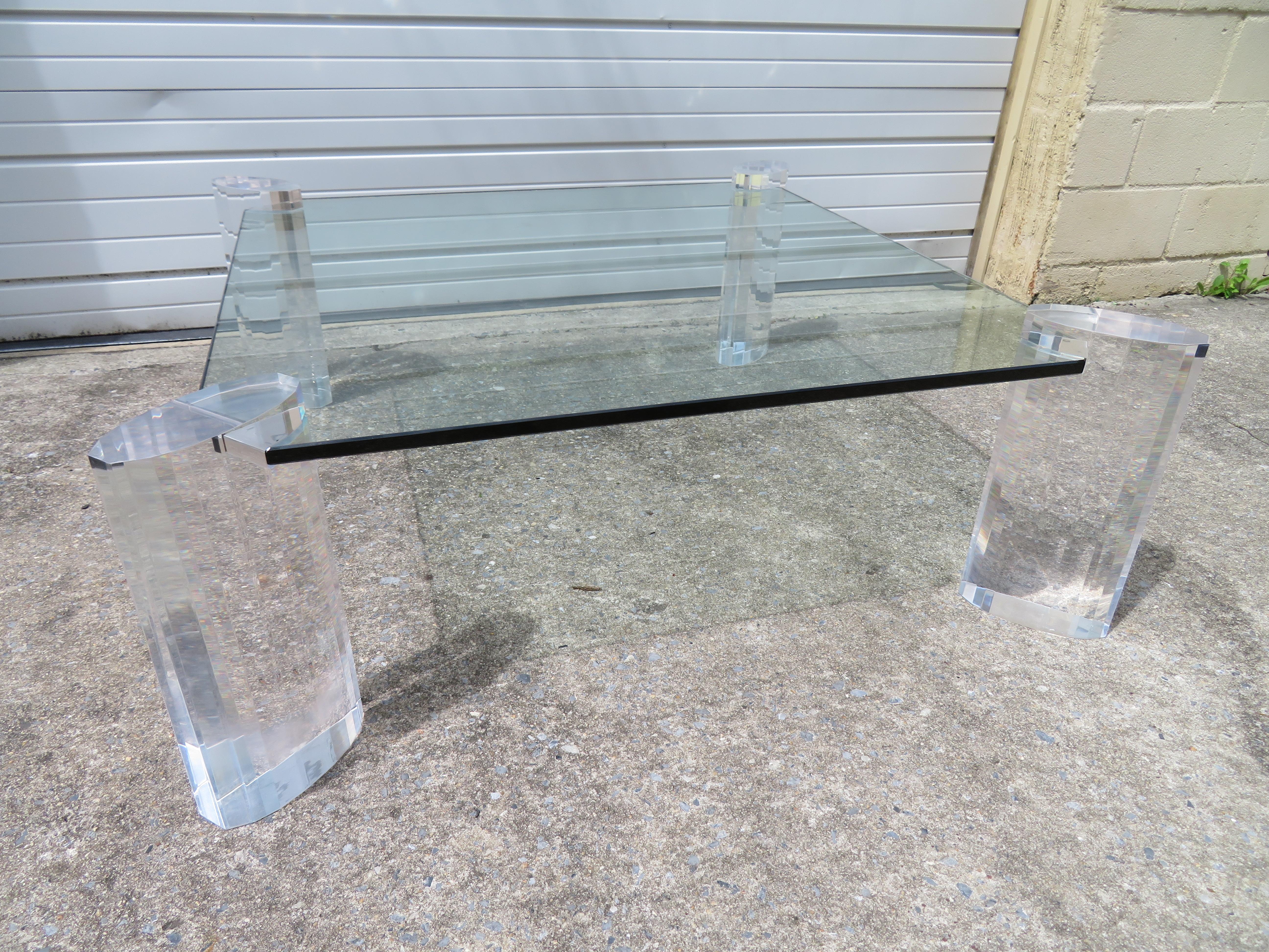 Magnificent Karl Springer style faceted Lucite pillar coffee table. This piece looks like an expensive piece of jewelry and is just gorgeous in person. The thick chunky lucite pillars are faceted giving them a brilliant sparkle like diamonds. This