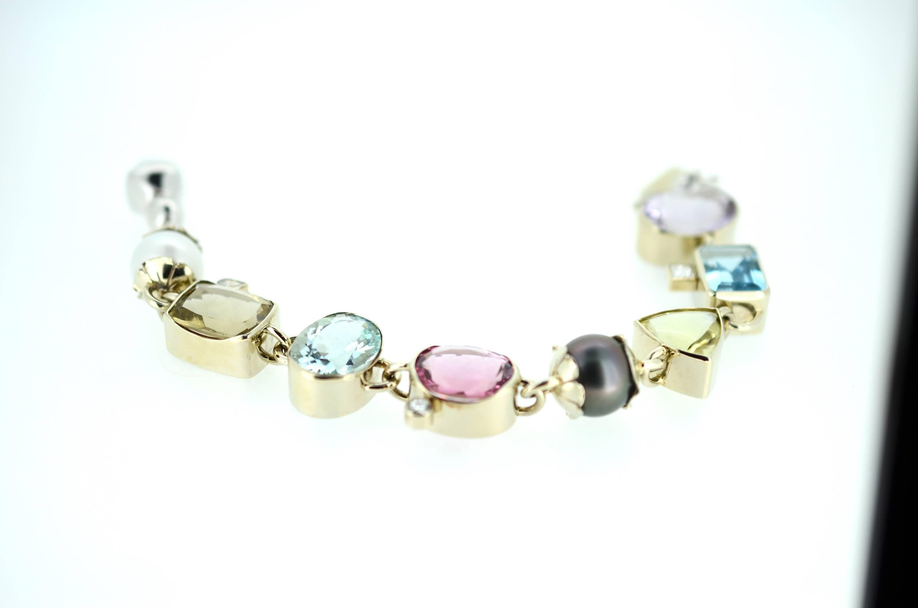Magnificent multi-gemstone bracelet hand fabricated in 18kt white gold with 18kt white gold clasp. Bezel set stones:
13.0mm Tahitian pearl, 12.5mm South Sea pearl, Two Lemon Citrine: 14.5X14.5mm Trillion, 17.0X13.0mm Cushion Cut, Pink Tourmaline