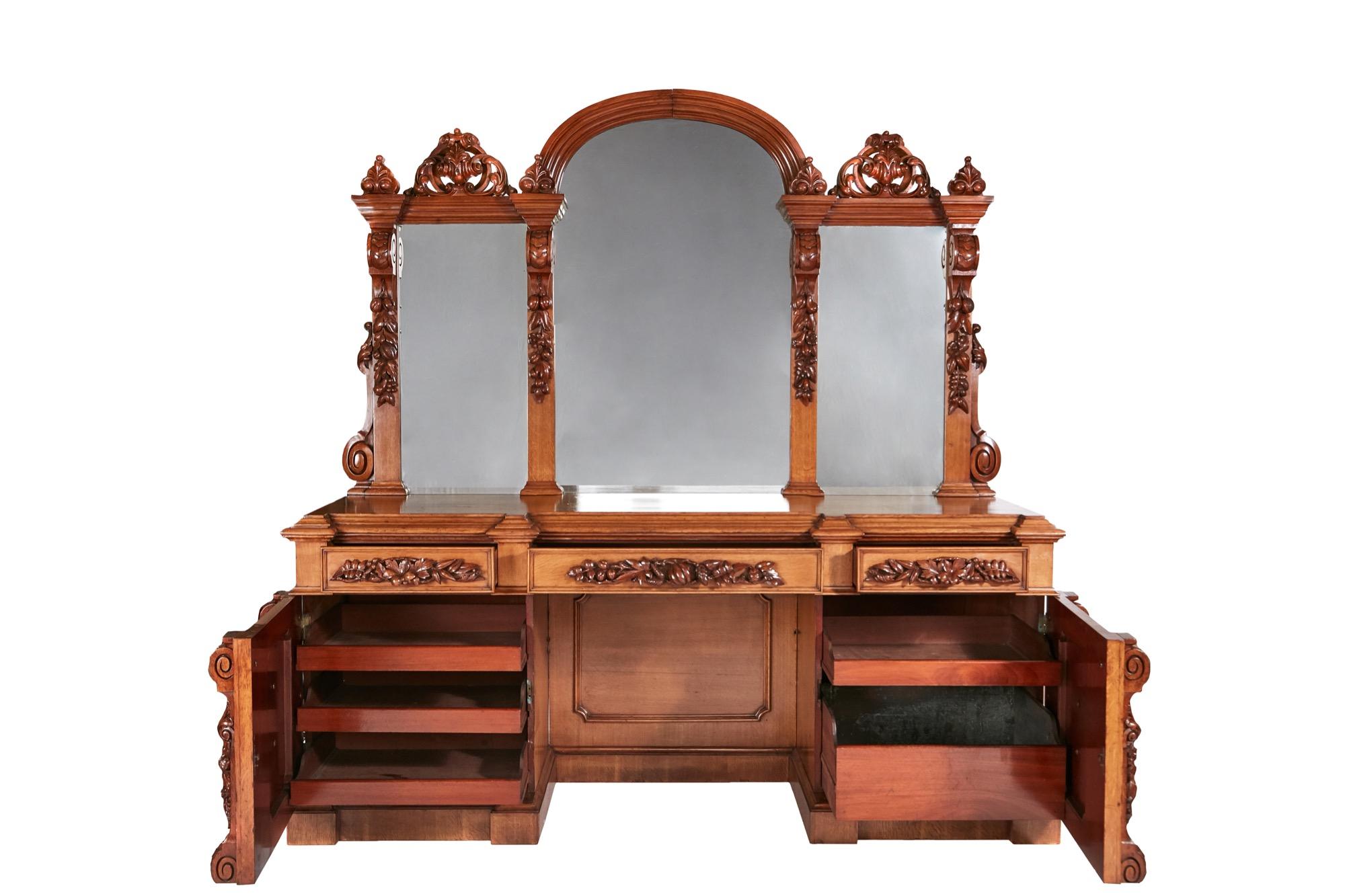 This is a magnificent 19th century Victorian antique carved oak mirror back sideboard which has a large mirror back with delightfully carved pears, apples and fruits. The base with three carved frieze drawers, two cupboard doors with carved grapes