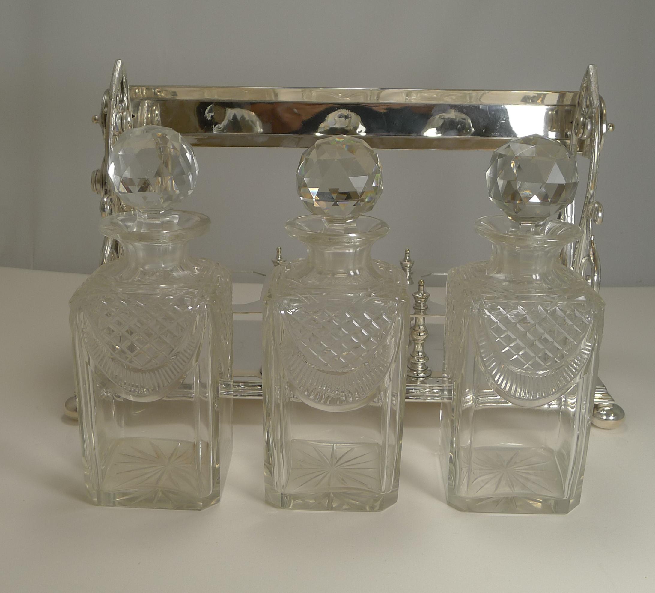 A magnificent and very grand late Victorian three bottle tantalus dating to circa 1900.

The frame is made from silver plate with a fabulous handle to the top and highly decorative end panels. The lock comes with a working key and when unlocked
