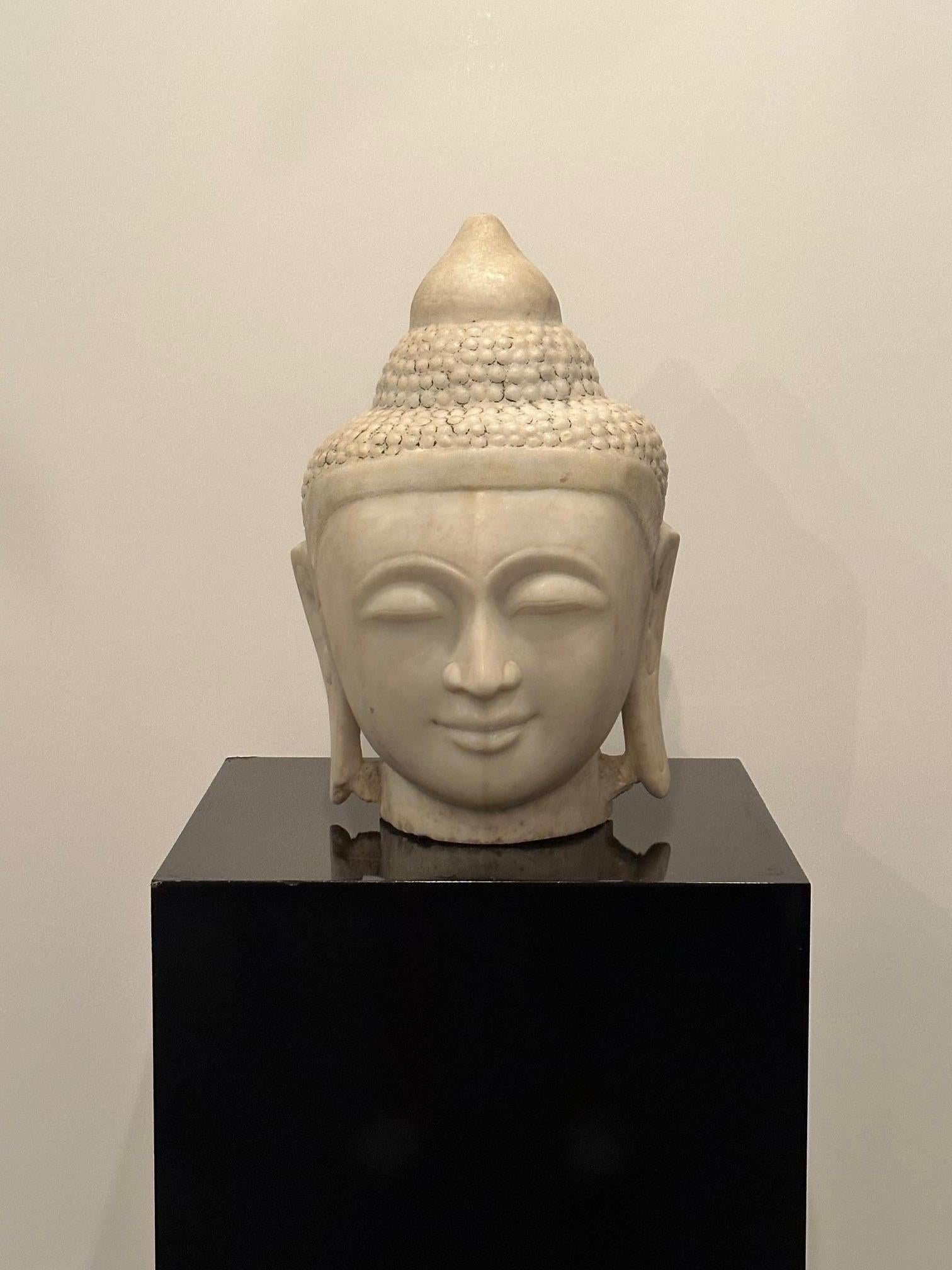 Magnificent white marble antique Buddha head in a large size, having a beautiful peaceful expression.