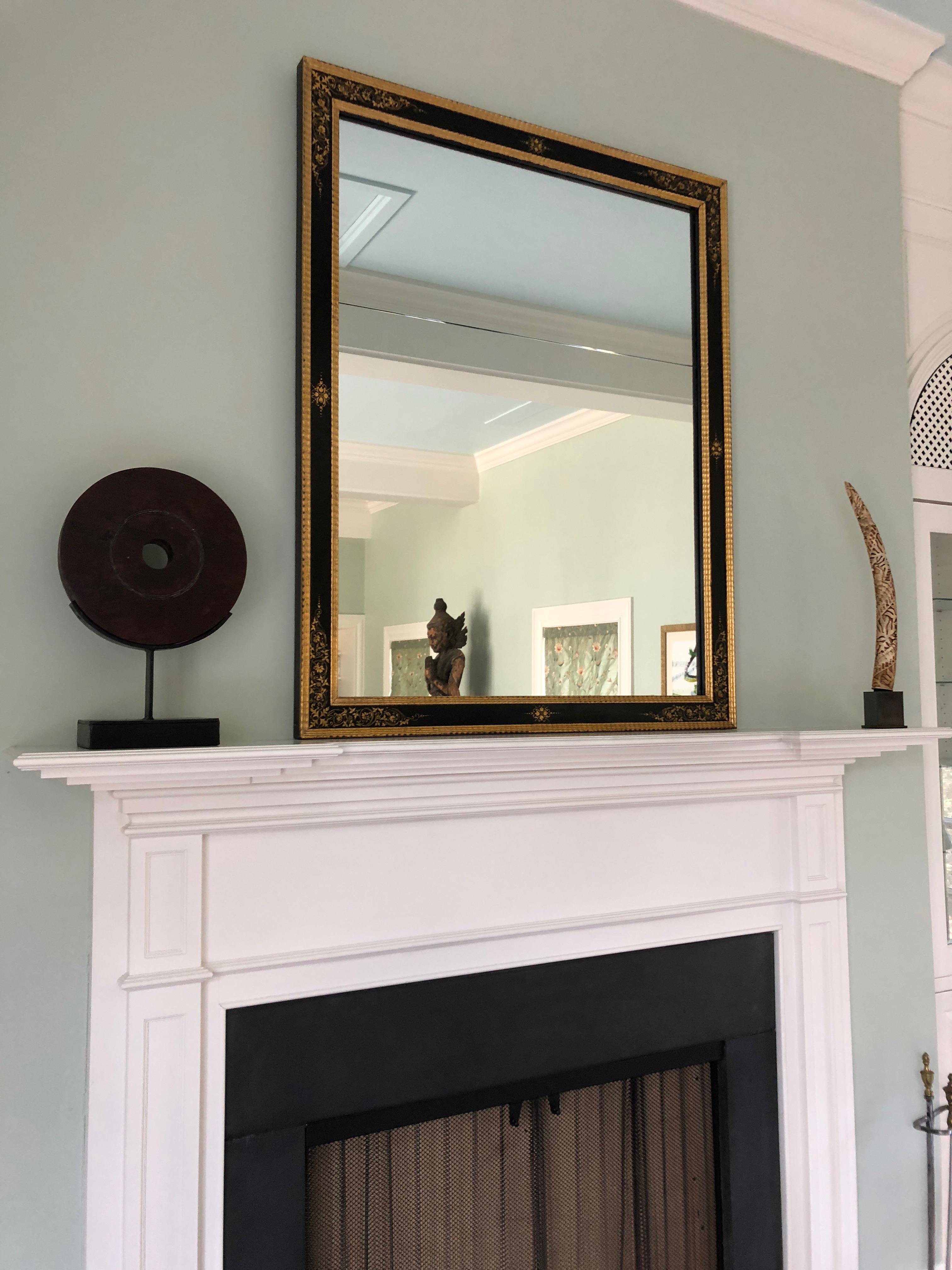 Très élégant miroir rectangulaire noir et or avec des bords en bois doré et de beaux motifs peints sur le cadre. Le miroir est en deux parties, comme c'est souvent le cas pour les grands miroirs anciens. Le miroir mesure 35,75 x 48 et le cadre est