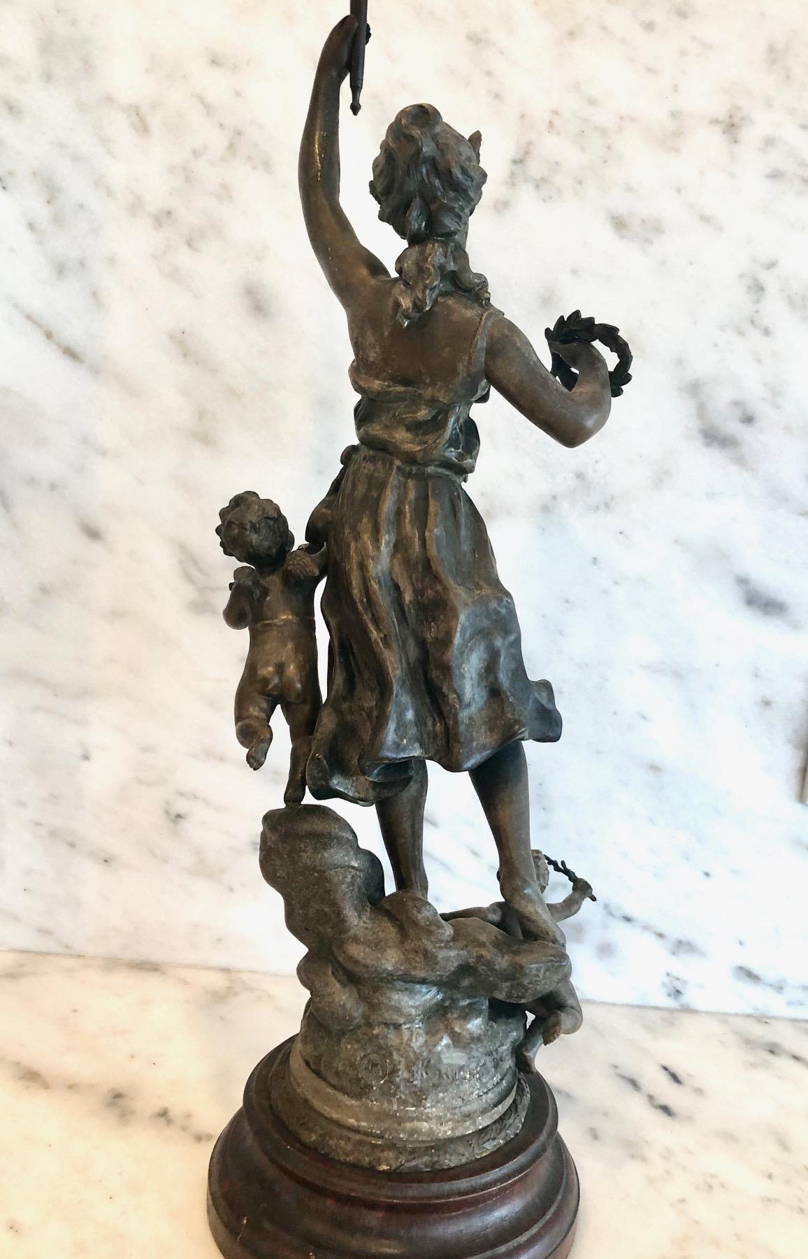 Stunning large bronze sculpture with brown patina titled Avenir et Fortune
(Future and good Fortune) depicting a proud beauty with raised arm holding a torch, accompanied by small putti at her side. Sculpture stands on an octagonal dark red veined