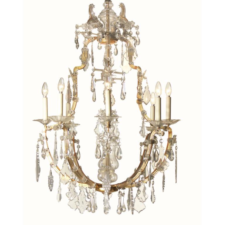 Saloon chandelier crown-shaped Baroque style, hand-wrought metal-frame in gold colour, partly covered with glass, rich in hand-cut glass decoration, eight flames.
Materials & Techniques Notes: bronce hand-wrought, glass bars, hand-cut crystal