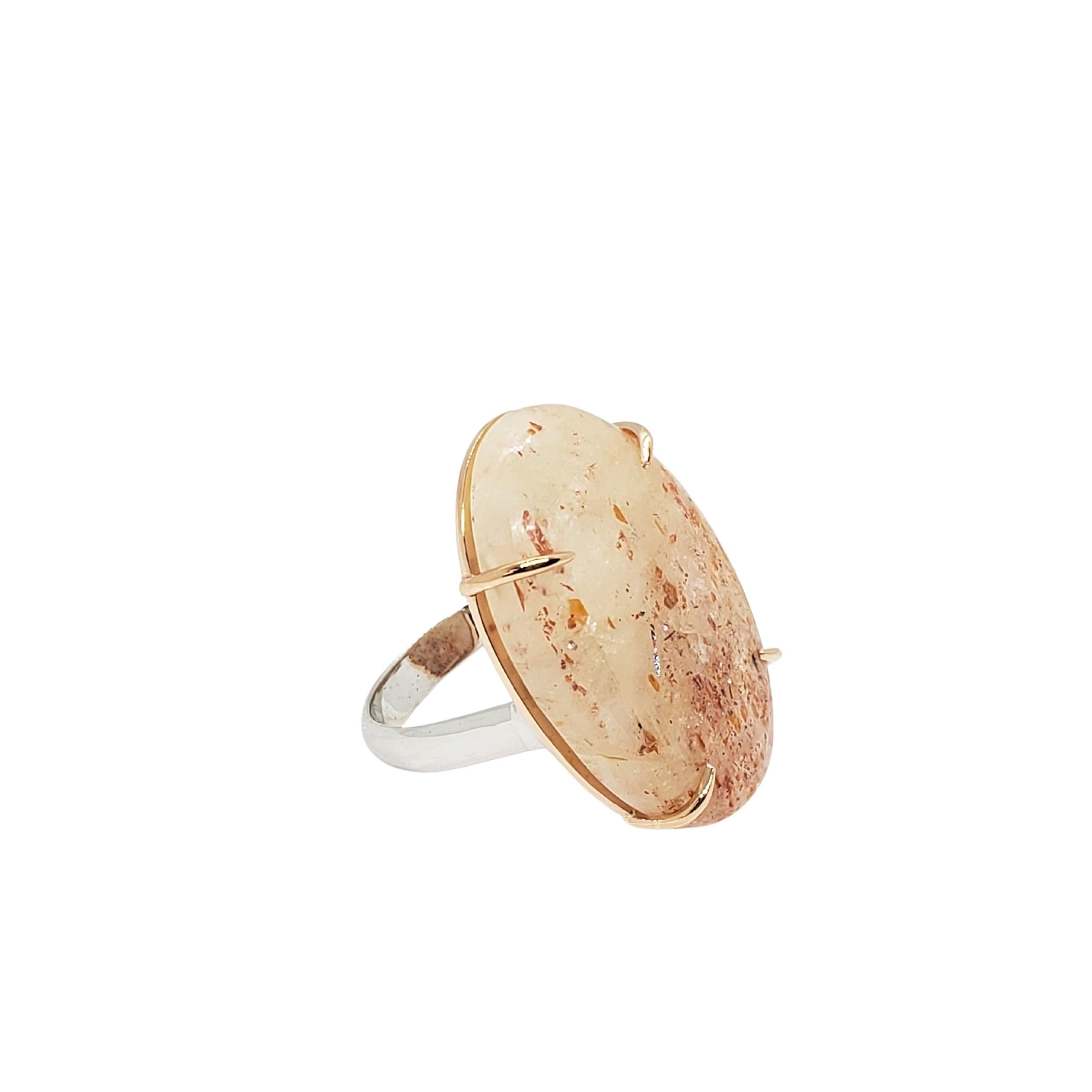 Merging Pink Gold, White Gold and a beautiful Sunstone Oval cabochon gemstone with optical shimmering results in a mouth dropping style. The band in polished 14K white gold is assembled to a polished 14K pink Gold custom setting with an open back