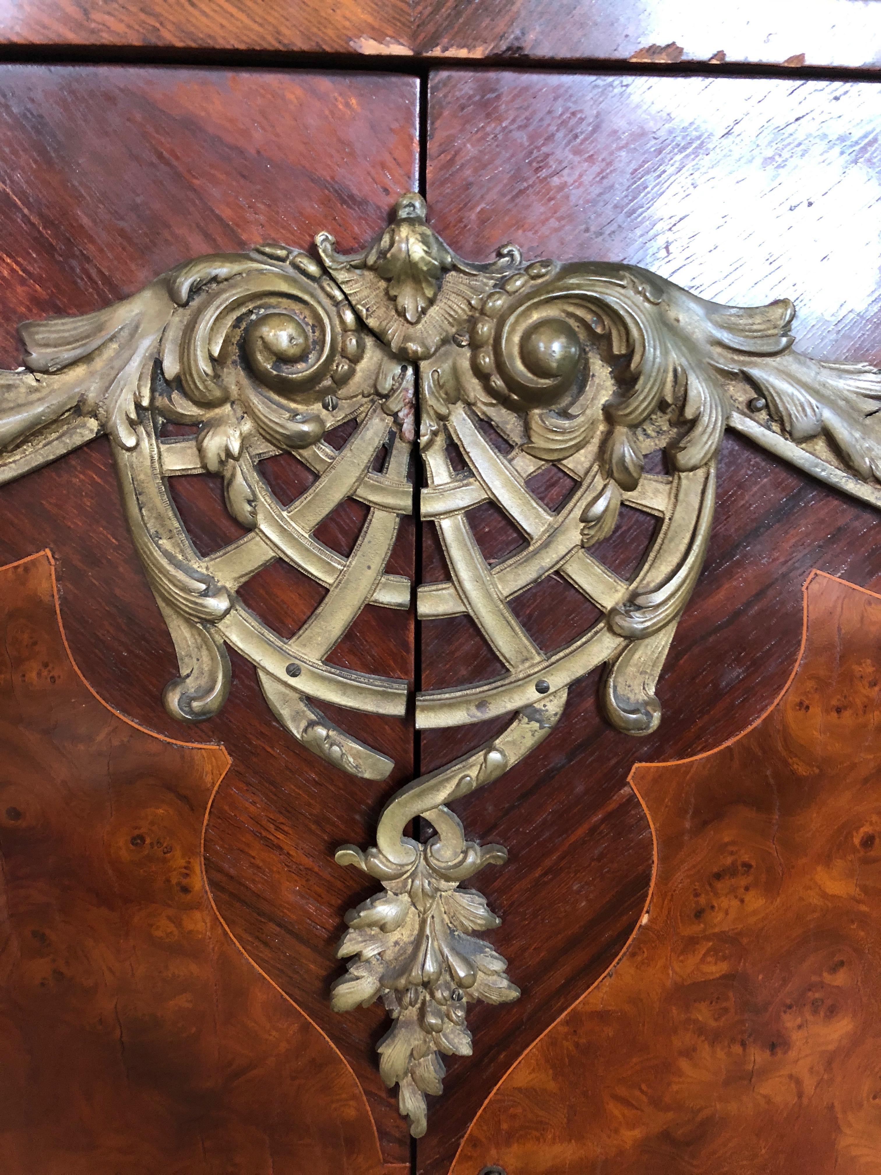 Elegant Louis XV style early 20th century credenza having a conforming molded rouge marble top, booked diagonal fruitwood veneer with burled panels on the front two doors and ormolu mounts and feet. Very good condition. Holes are drilled in back for