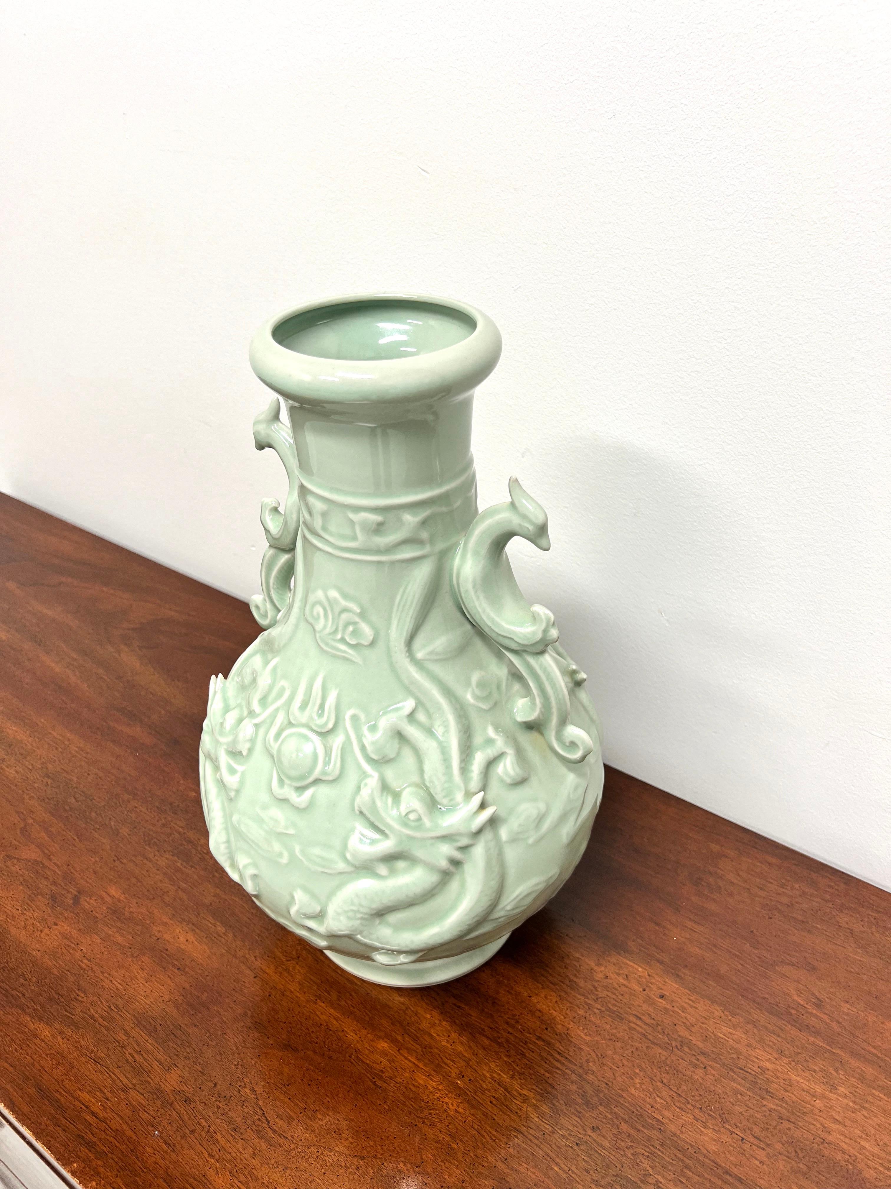A Chinese Export large dragon motif porcelain urn with bird-like handles. Unsigned, artist unknown. Green color porcelain with a glazed finish. Made in China, in the mid 20th Century.

Measures: 10w 10d 17.25h, Weighs Approximately: 14