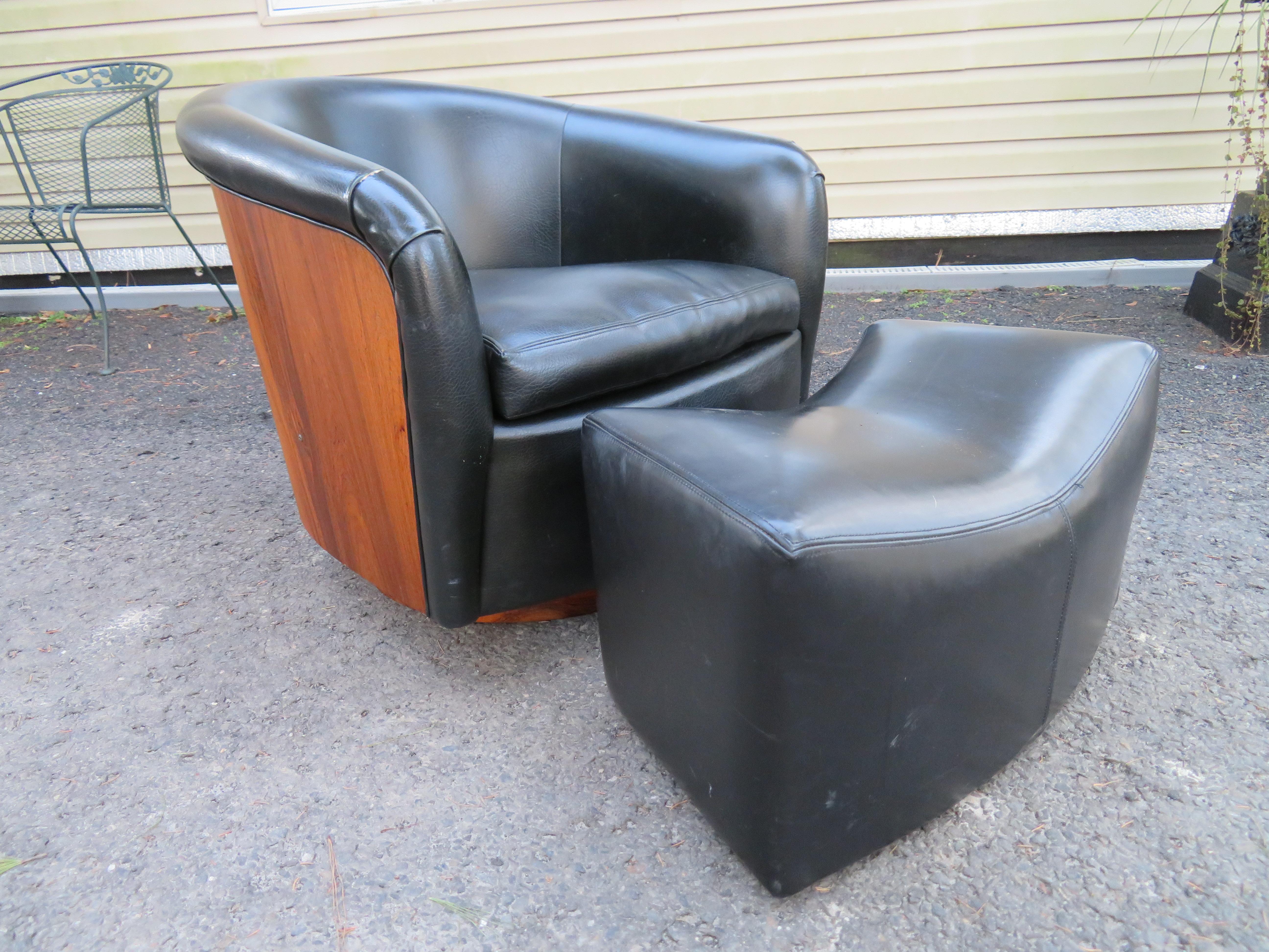 Magnificent and rare rosewood wrapped swivel tub chair in faux black leather with matching rolling ottoman by Milo Baughman, 1970s. This set is quite nice as is with original black faux leather-some wear to one arm but we recommend reupholstery to