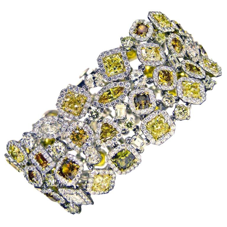Mehrfarbiges und mehrförmiges Diamantarmband aus Platin mit 57,70 Karat intensiv gelben, cognacfarbenen, grünen, orangefarbenen und weißen Diamanten, gefasst in  Halo-Design Jeder Diamant ist mit weißen Mikro-Pflasterdiamanten umgeben.
Diana M. ist