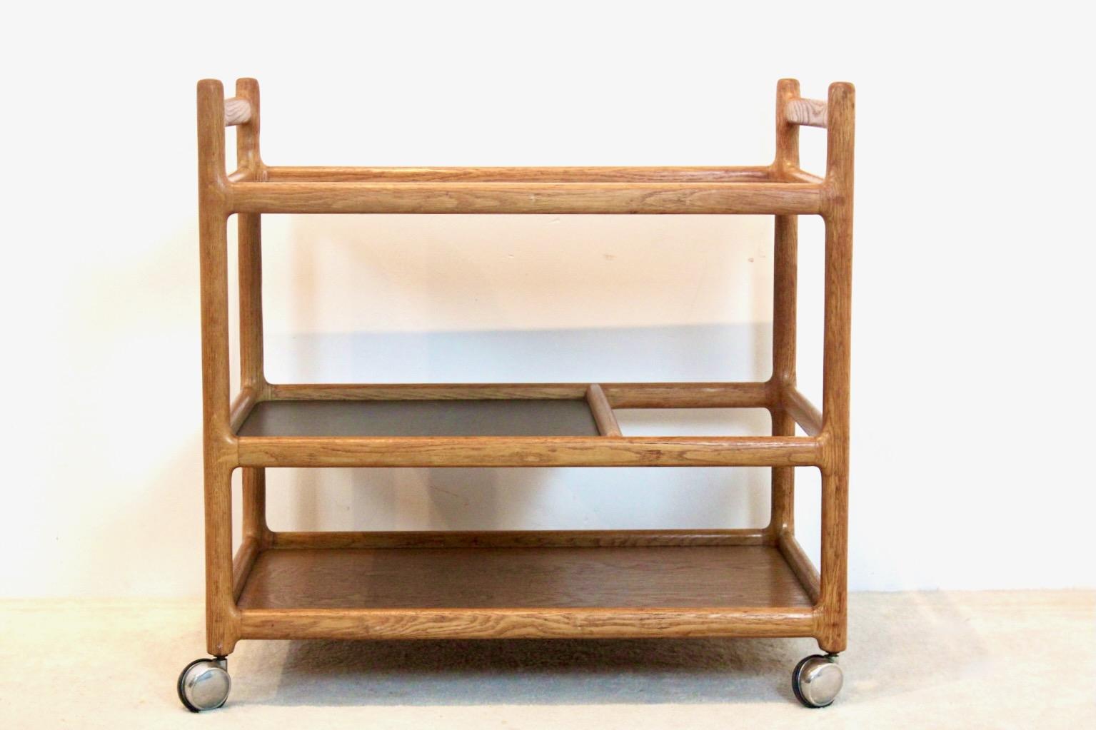 Magnificent Oak trolley designed by Korch Henning. Produced by CFC Silkeborg Møbelfabrik in Denmark. This bar and serving cart is made from solid oak and one black laminate tray, riding on fully working chromed casters. Excellent and original