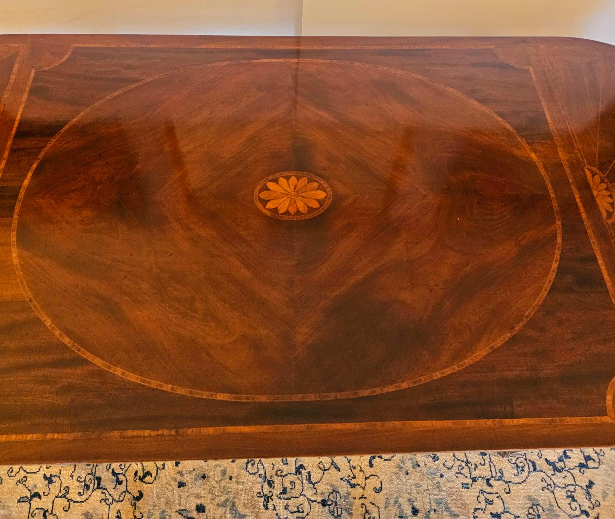 Consola alargada o mesa de comedor estrecha de gran elegancia, con tablero de caoba y madera de satén finamente trabajados con un precioso diseño de rayos de sol, complementado con una base pintada en gris celadón con detalles dorados.