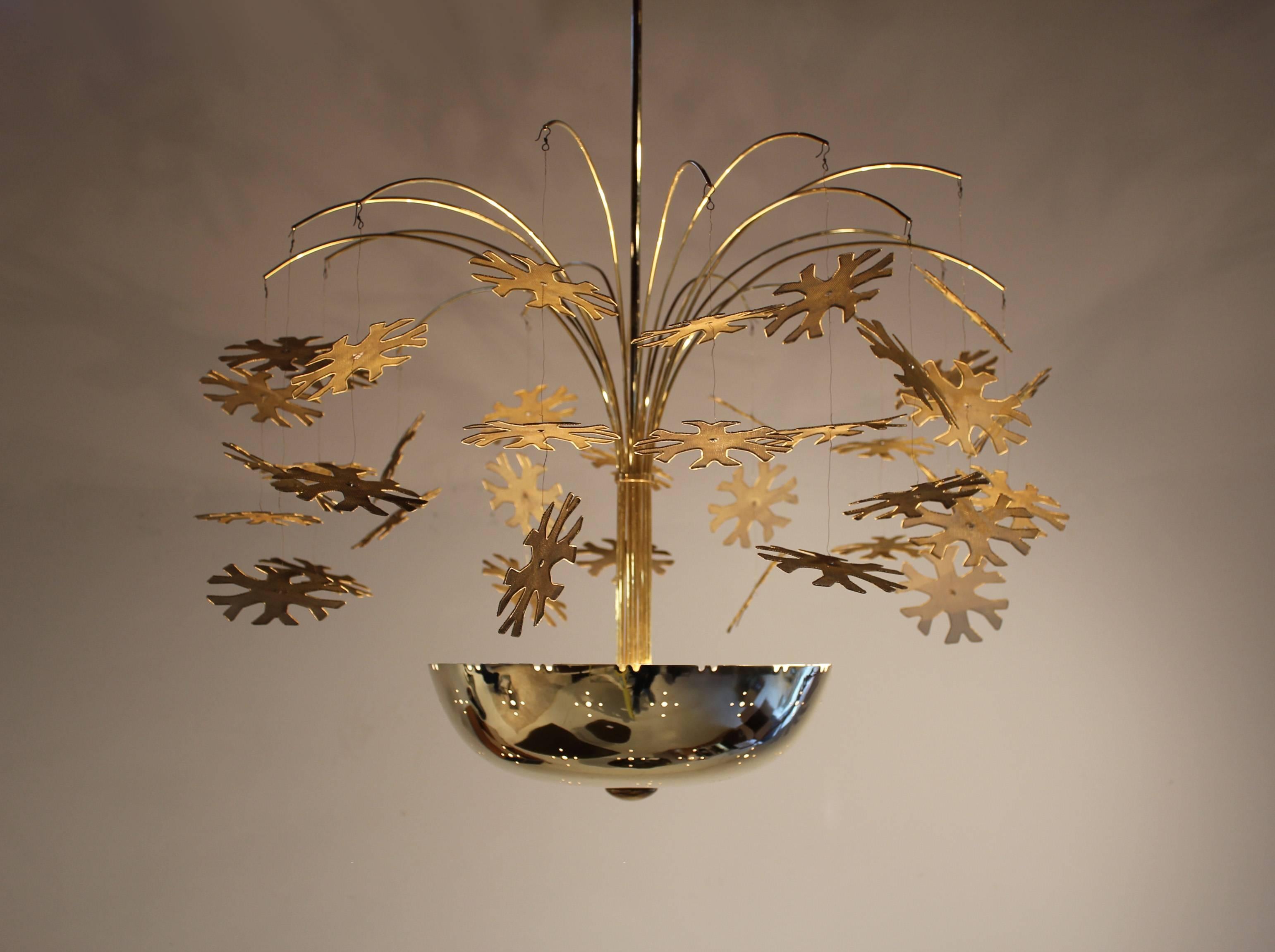 This is the quintessential Scandinavian modernist Snowflake chandelier by Paavo Tynell for Taito Oy and is currently on display in the 20cdesign showroom in Dallas Texas. This breathtaking chandelier casts a warm glow of light from the intricately