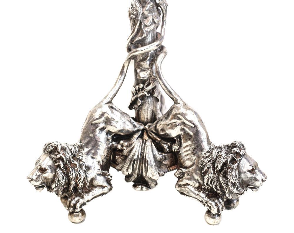 A magnificent pair of 800 silver seven-light Mario Buccellati candelabras, circa 1950. The base consists of three lions intertwined with leaves. Applied ivy leaves to the stem terminating in three rams heads. Foliate scrolls to the sconce consisting
