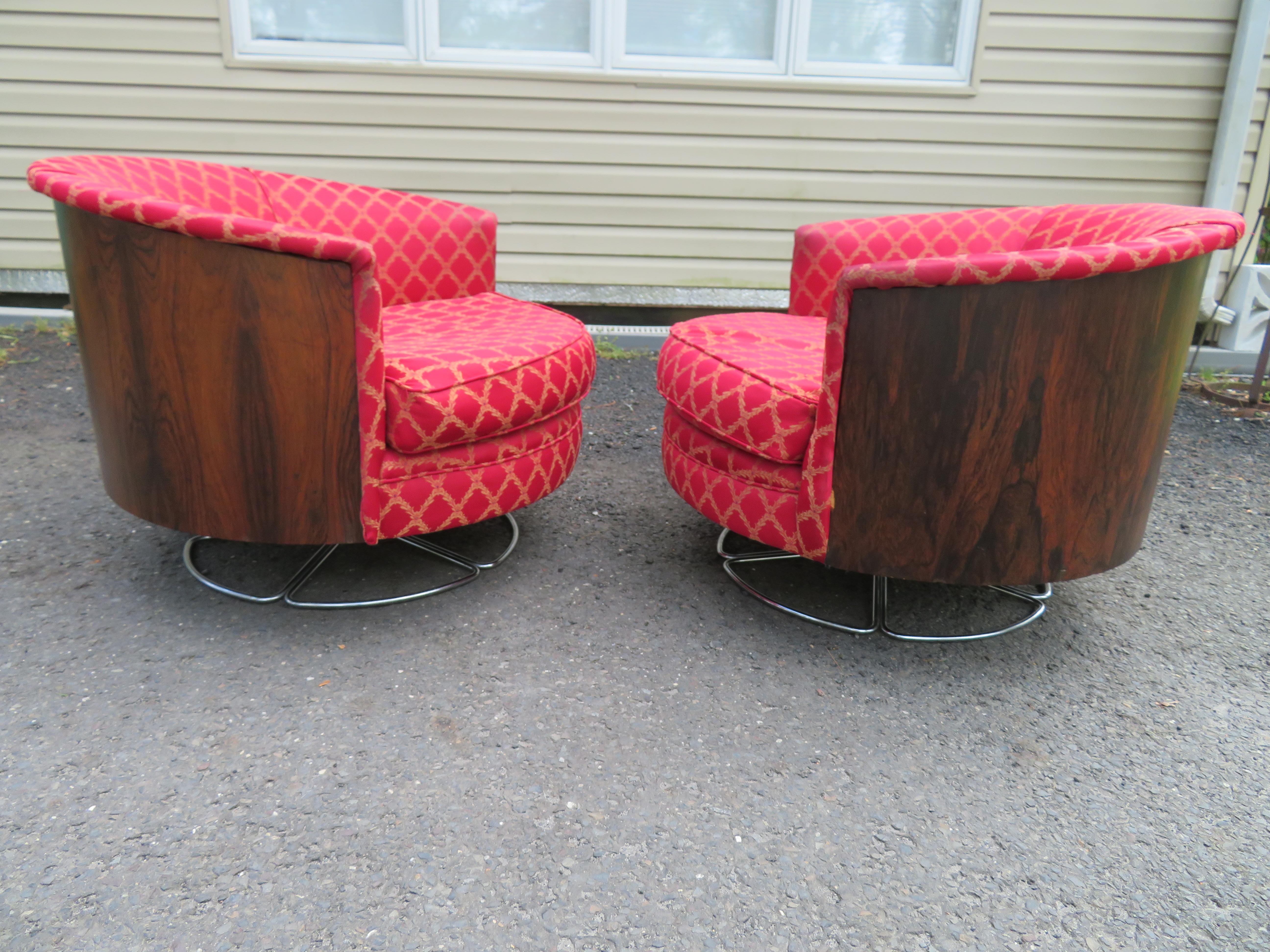 Magnificent pair of Milo Baughman style rosewood swivel chairs by Selig. These fine and rare chairs were reupholstered back in the 80's and still look presentable. The rosewood is dark and rich and in great shape. They measure 25