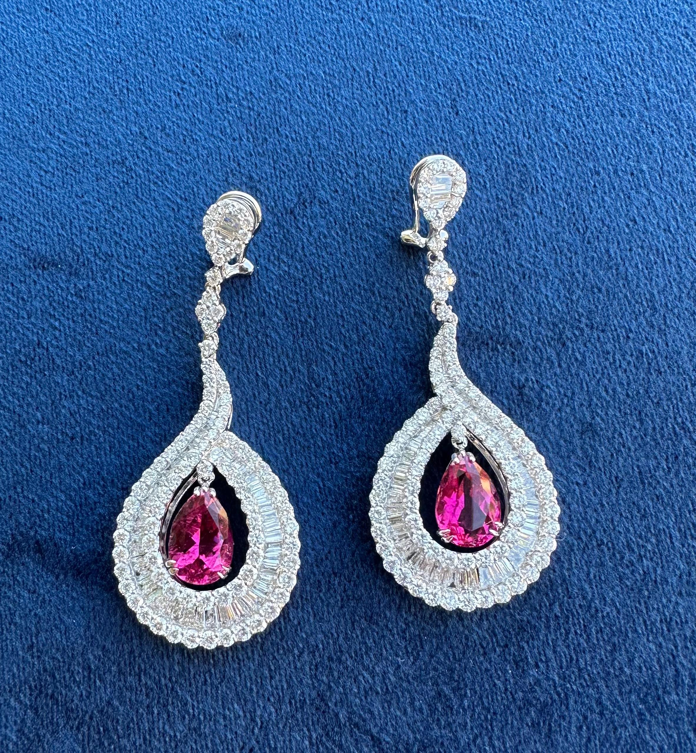 Magnificent, very dazzling in real life, pair of 18 karat white gold vivid pinkish red natural no heat Brazilian rubellite and diamond tear drop or pear shaped earrings, have a combined total carat weight of approximately 18.08 carats. 

The
