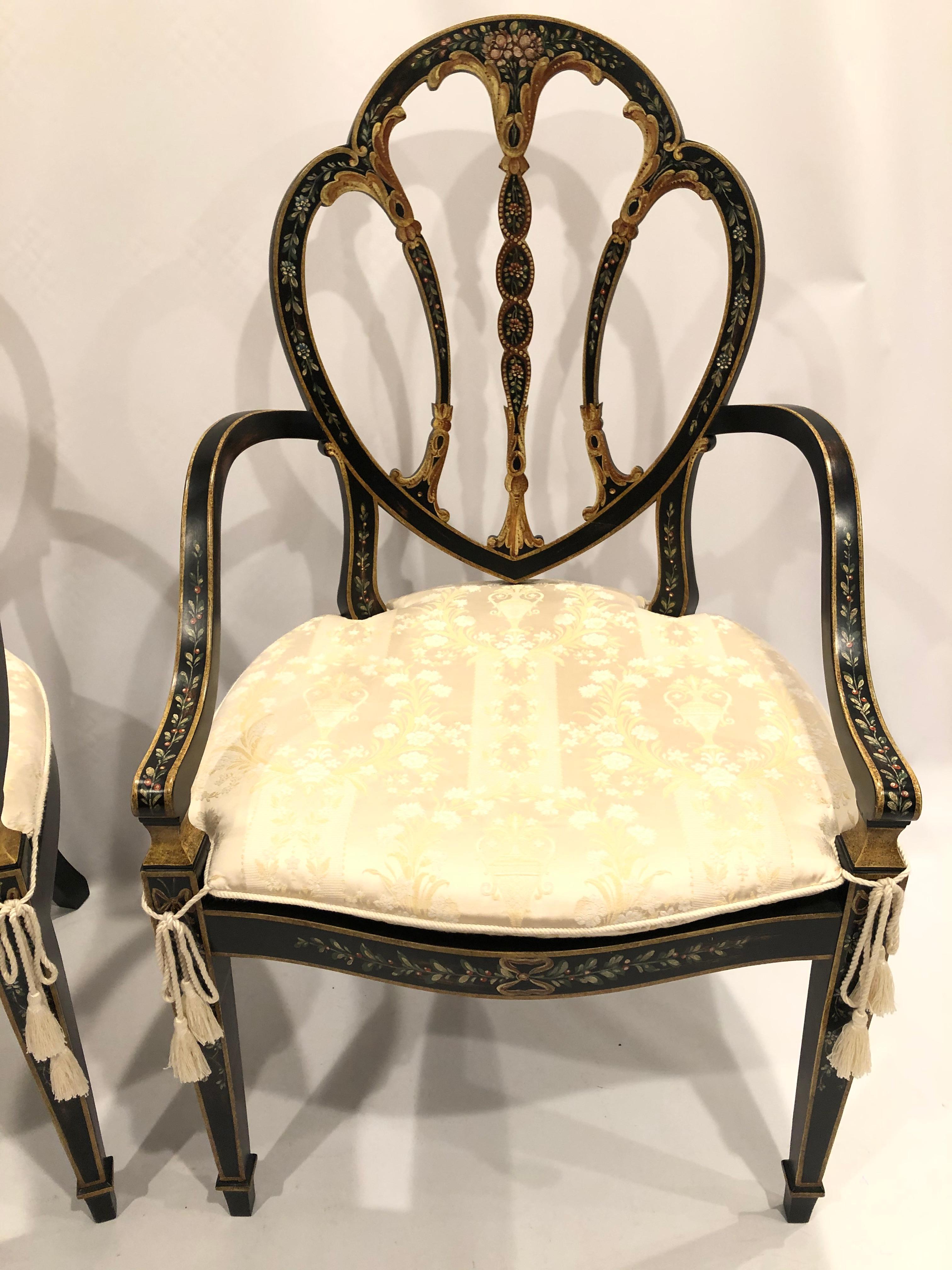 Superb pair of black painted shield back armchairs having lovely floral decoration caned seats and custom off white damask seat cushions.