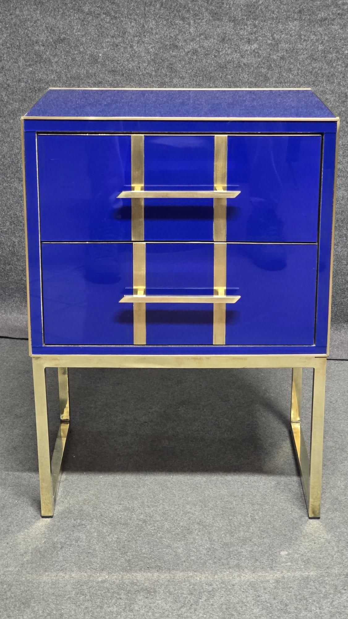 These beautiful bedside tables are handmade in Italy. They have a blue Murano glass top and drawers, hand-blown by skilled craftsmen. 

The bedside tables are made of a sturdy birch wood frame with polished brass details. The interior is upholstered