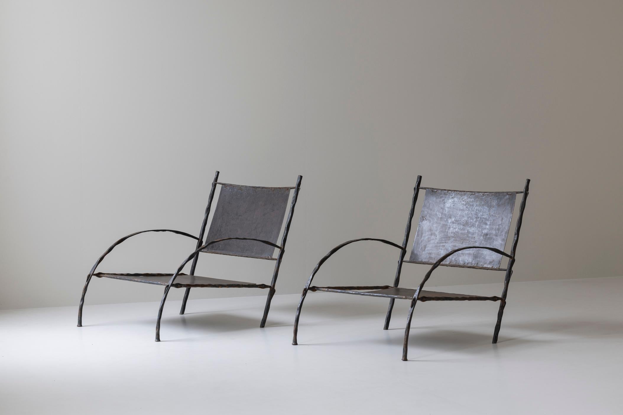 Magnificent pair of easy chairs, dating back to the 1930s, in the manner of Diego Giacometti. These chairs are crafted entirely from wrought iron, showcasing a striking combination of industrial design and artisanal craftsmanship reminiscent of