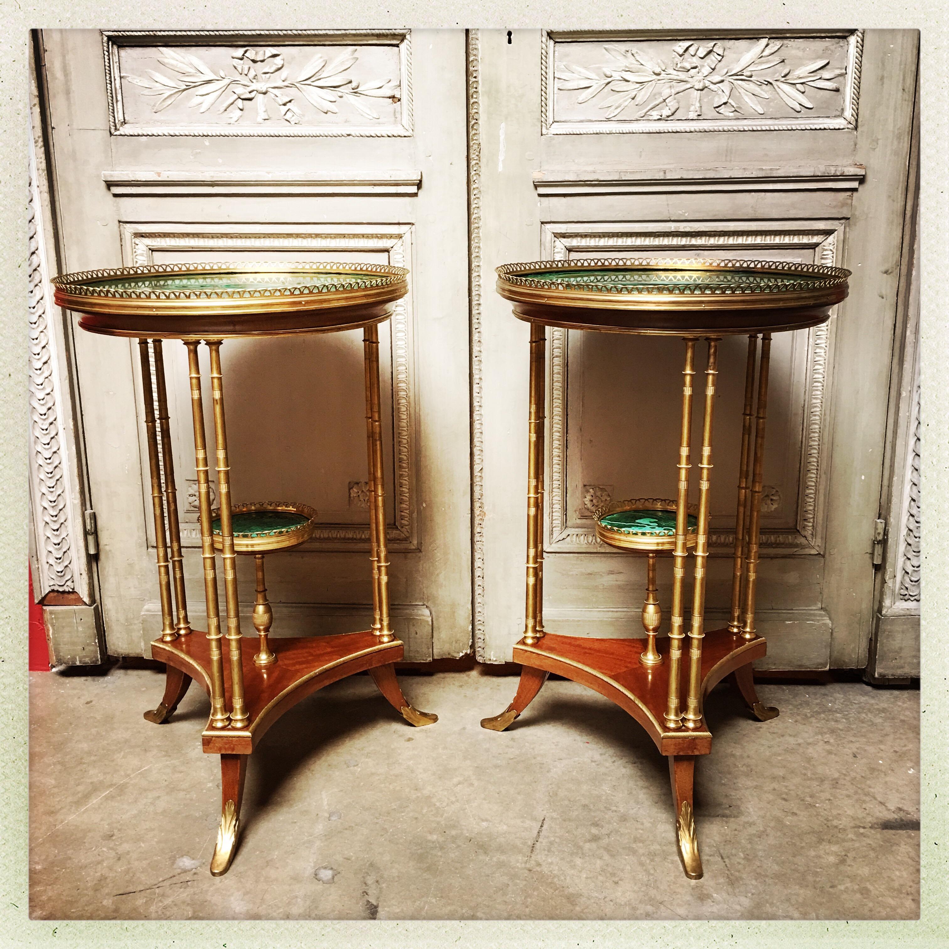 A pair of French Louis XVI style gueridon tables of bronze, mahogany and malachite of exceptional quality. Based on 18th century models by Adam Weisweiller.