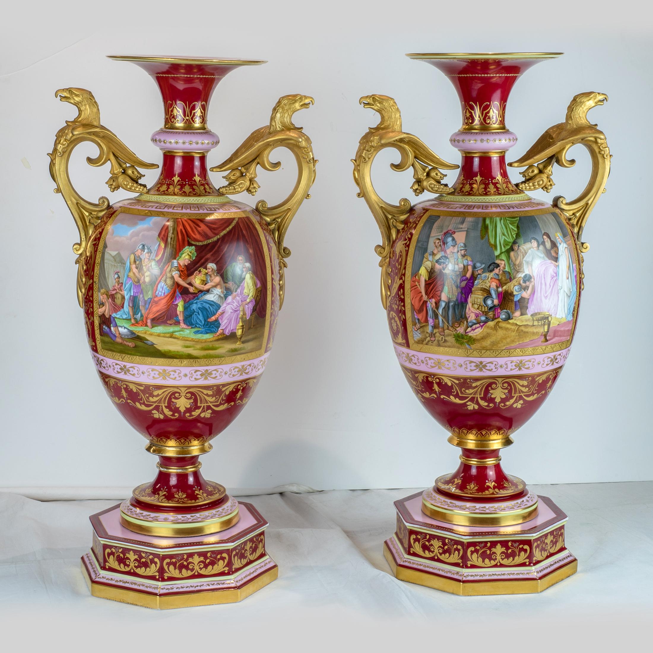 Magnificent pair of Royal Vienna-style porcelain urns each with a claret ground and a painted reserve depicting classical figures in allegorical theme. 

Date: 19th century
Origin: French
Dimension: 24 x 12 inches.