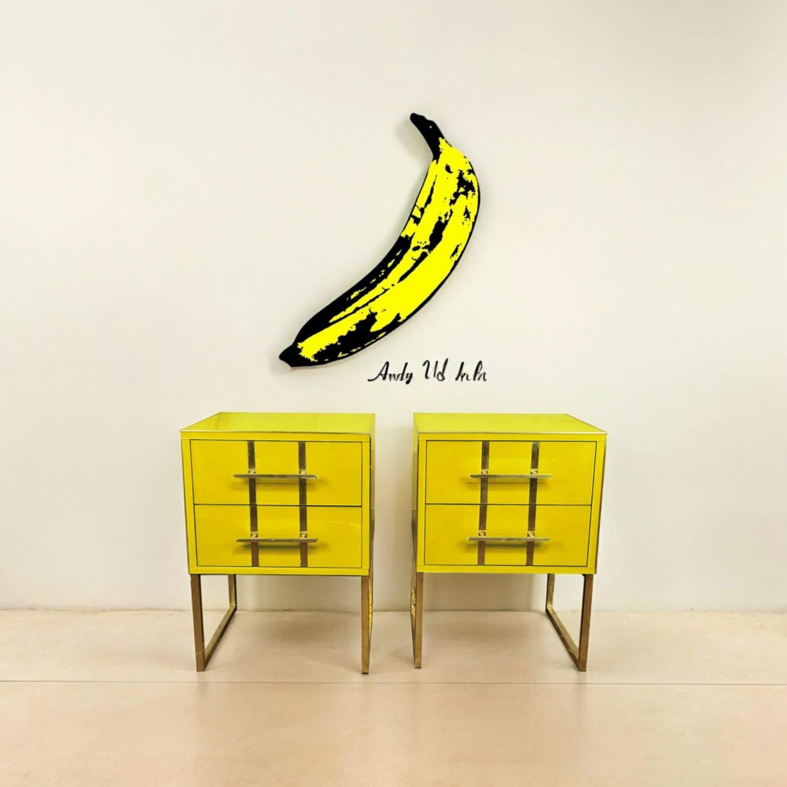 Magnificent pair of yellow bedside tables inspired by the iconic style of Andy Warhol. 

These stunning statement pieces, handcrafted in Italy, seamlessly blend modern design with traditional craftsmanship. 

The tops and drawers feature unique,