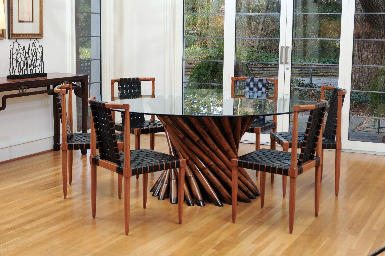 A remarkable restored pedestal bamboo cluster center or dining table by the Visionary Budji Layug, circa 1980. Large, mature stalks of cut bamboo cleverly constructed as a table base designed to shoulder a large heavy glass top. Stout and