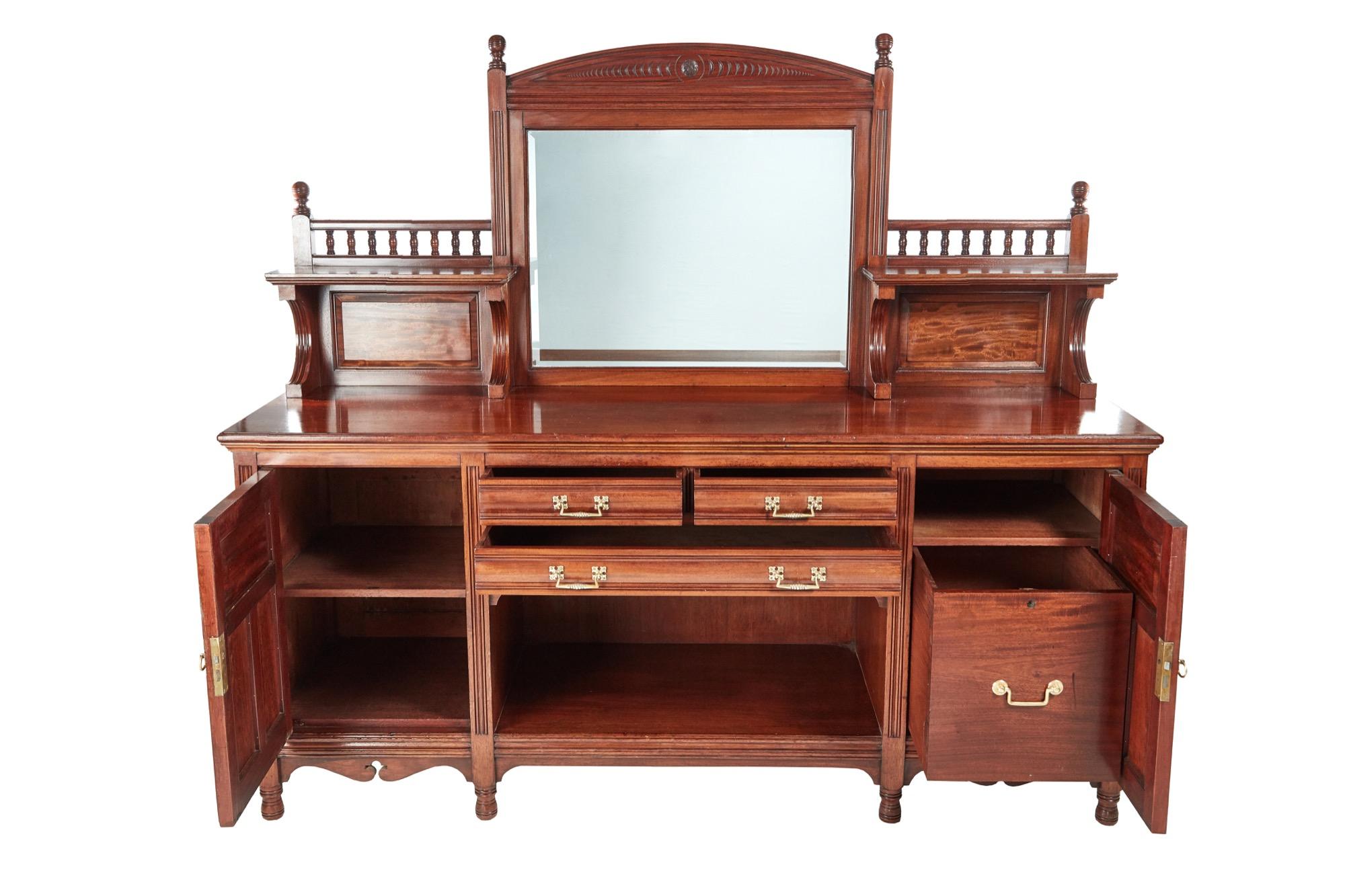 A superior example of a magnificent antique Gillow & Co mahogany sideboard. The quality and design is superb. An elegant looking mirrored back with carving to the top. The base has a splendid mahogany top. It has three drawers with original brass