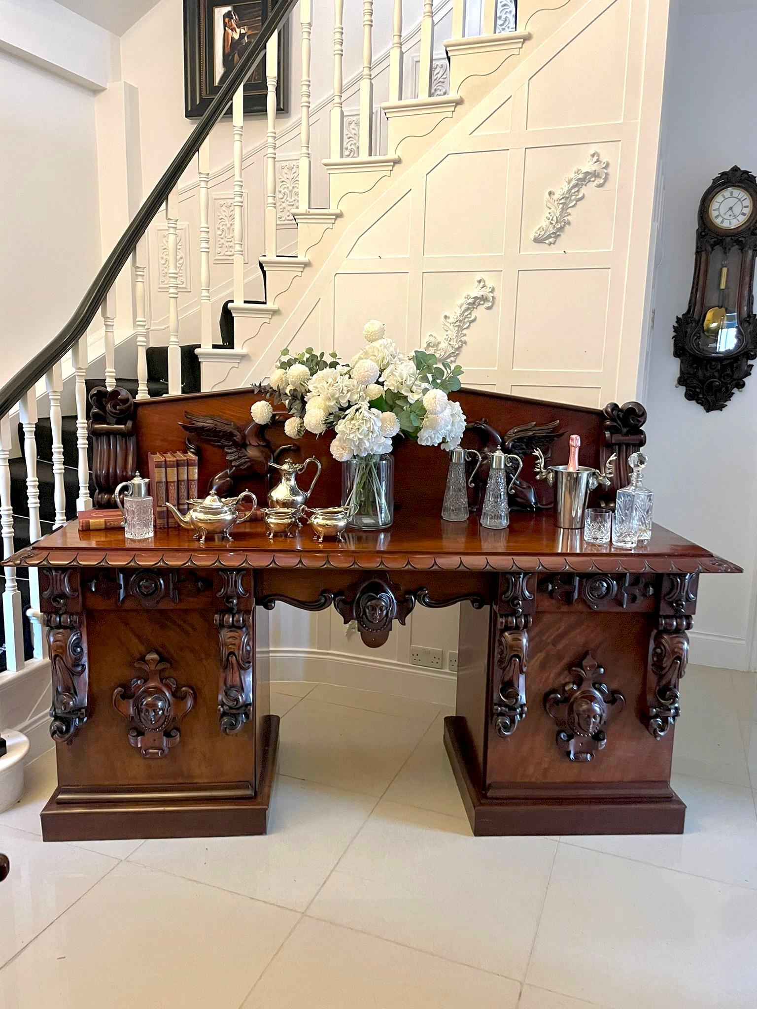 Magnificent quality antique William IV carved mahogany sideboard having an incredible pair of high-relief exceptionally detailed carved griffons flanking a central flaming urn. The base having an outstanding mahogany top with an exquisite carved