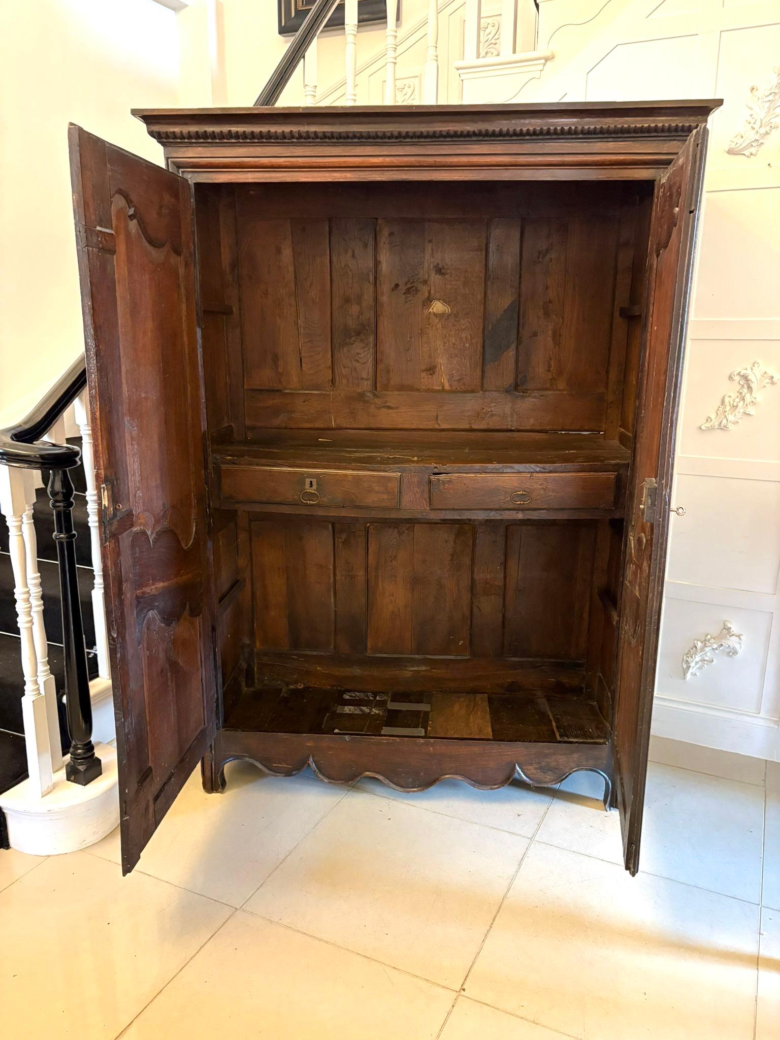 Un magnifico armoire in quercia di provincia francese della fine del XVII secolo di eccezionale qualità e presenza. Questo primo esemplare, risalente al 1680 circa, presenta porte a pannelli dalla forma splendida, con volute foliate finemente