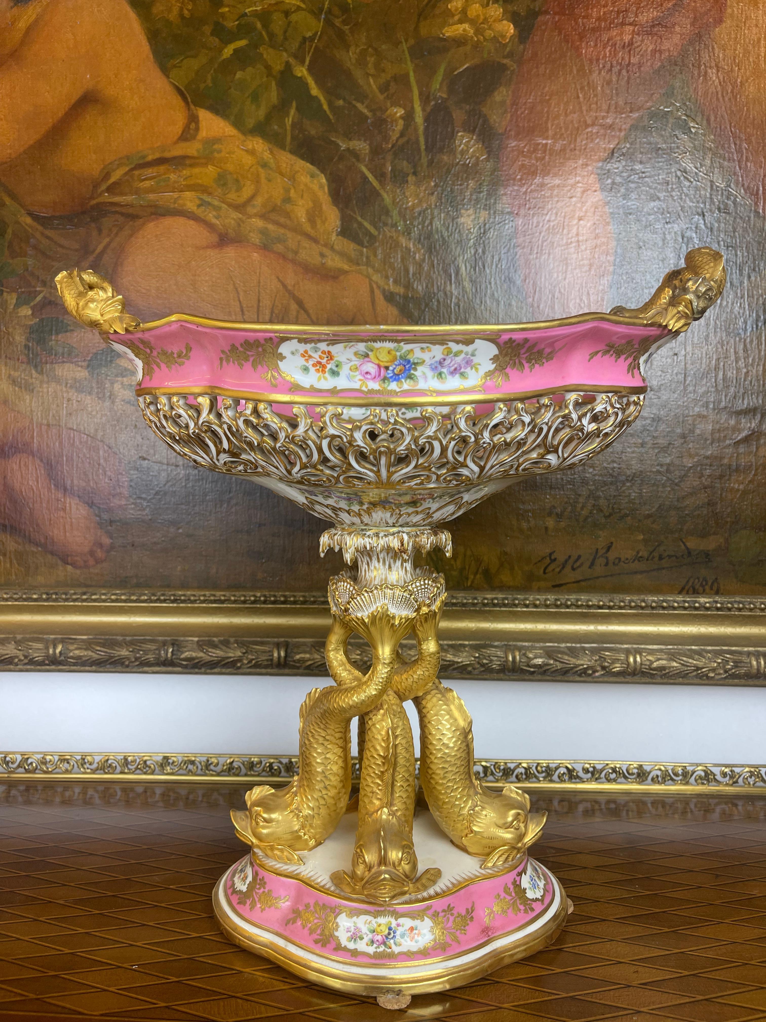 A magnificent & rare georgian pink ground porcelain centerpiece possibly by Minton. Retailer's mark for Daniell London. Circa Mid 19th. Century. The pierced two handled basked supported by three dolphins laid on a oval base. 

Measures: