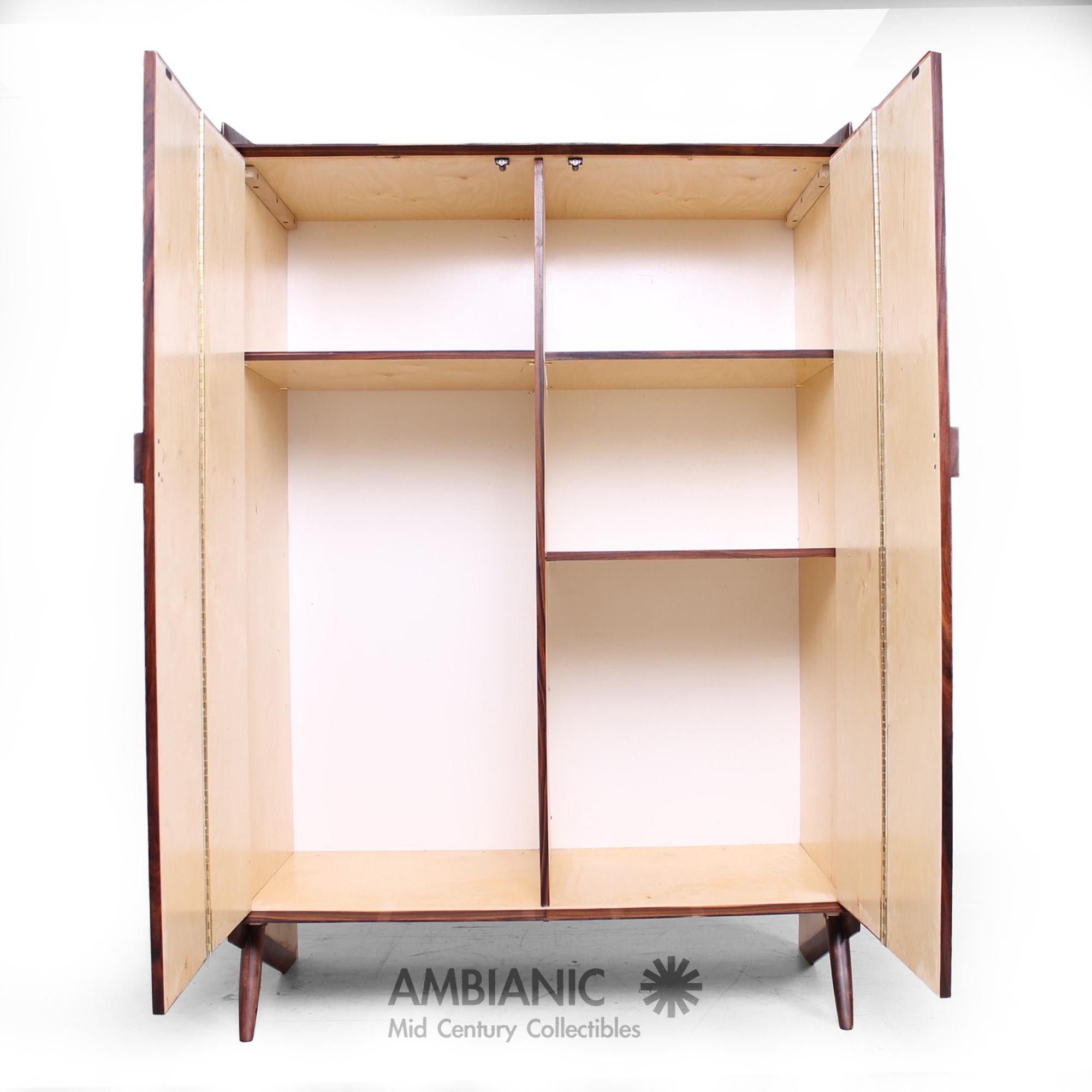 An exquisite custom rosewood armoire gentleman's cabinet
Fabulous wood grain beauty!
New production designed by Pablo Romo for AMBIANIC, 2016.
Features an open storage with adjustable shelves. Pegs legs at a skewed angle with unique