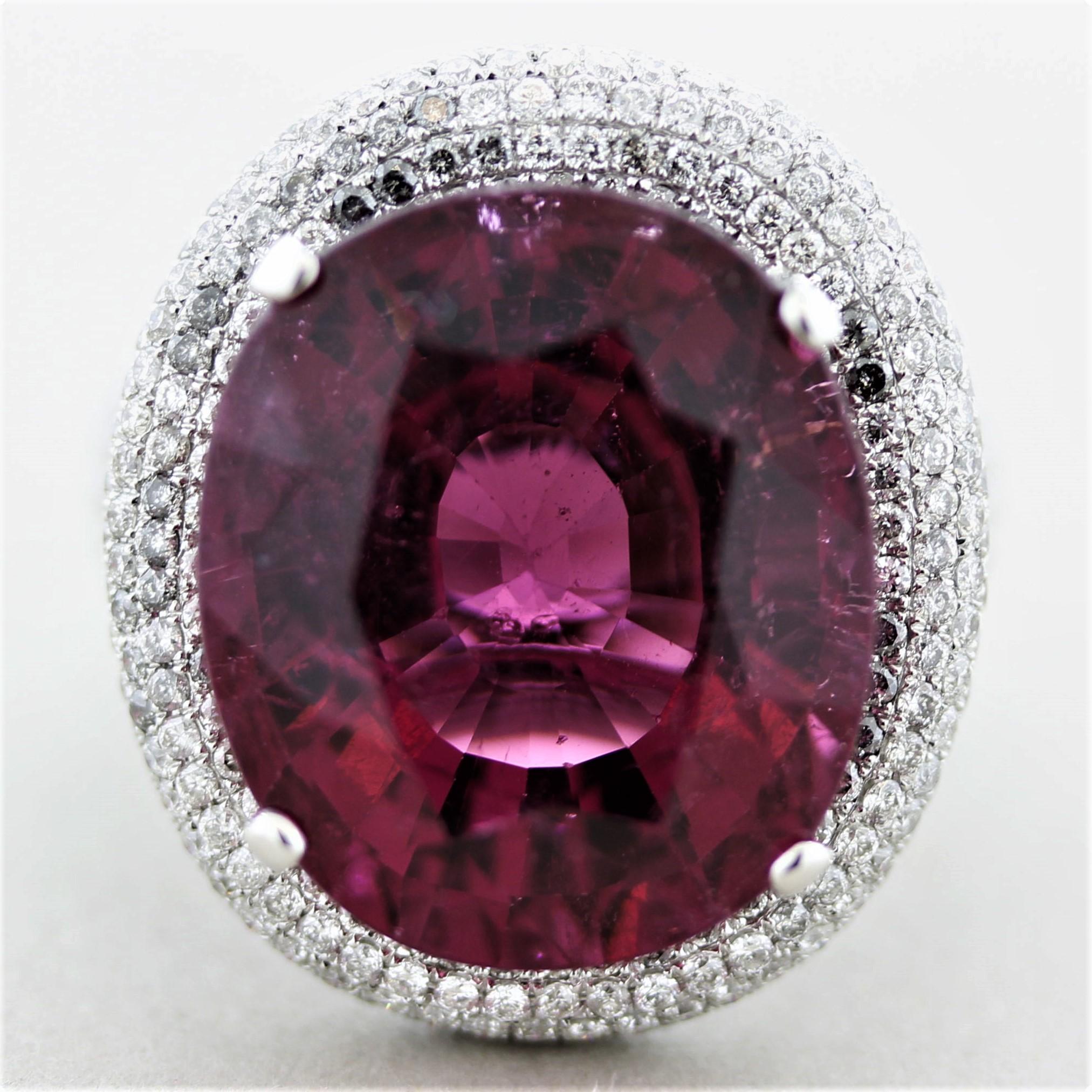 An extra fine and special tourmaline takes center stage. The tourmaline has a bright and intense top quality raspberry red color and weighs a staggering 21.56 carats. An exceptional stone for its size, color, clarity, and brilliance. It is accented