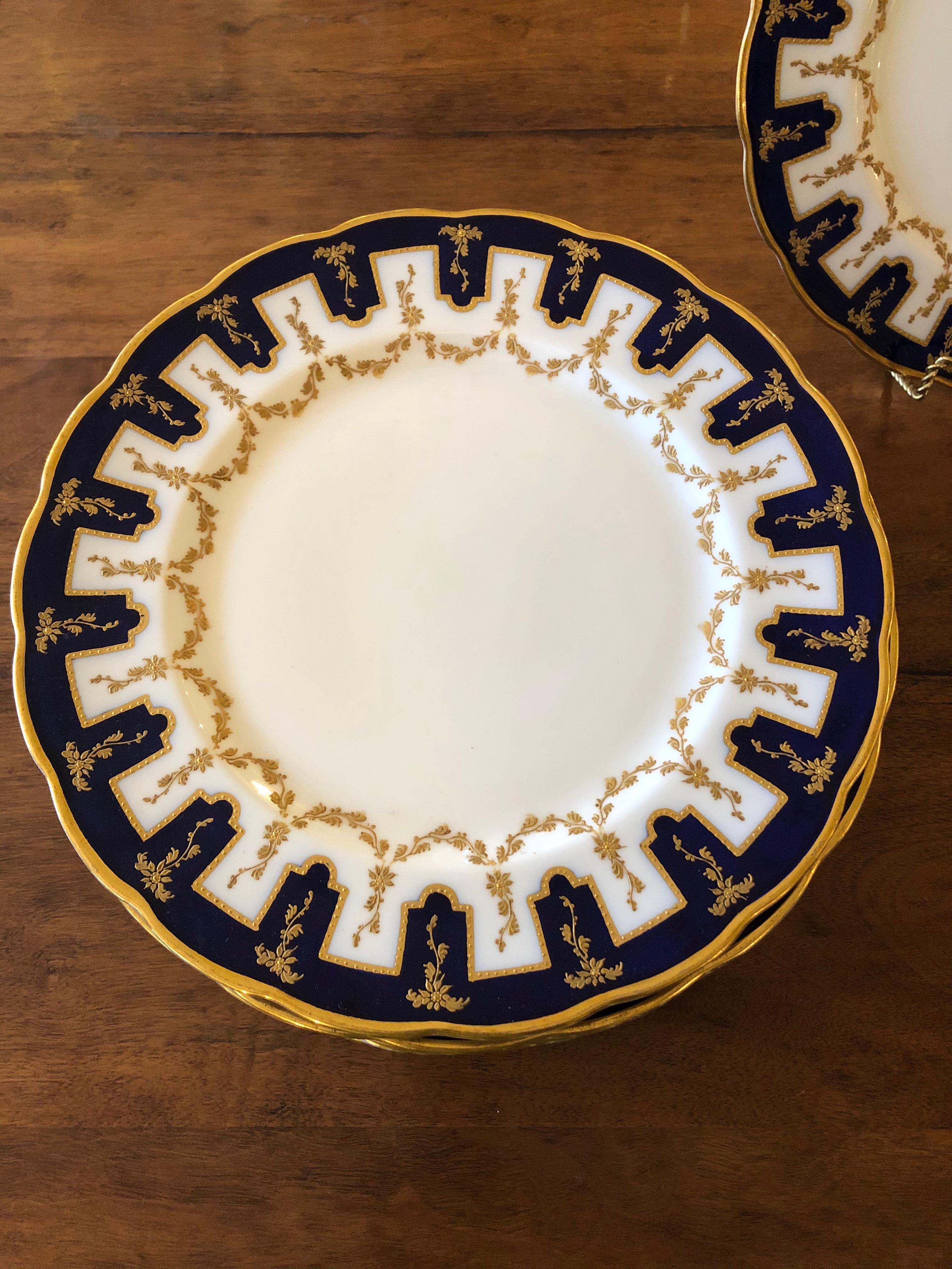 Incredibly regal formal set of 12 Ovington porcelain dinner plates having heavy gold relief and cobalt blue design with lovely scalloped edges. Marked on backs.