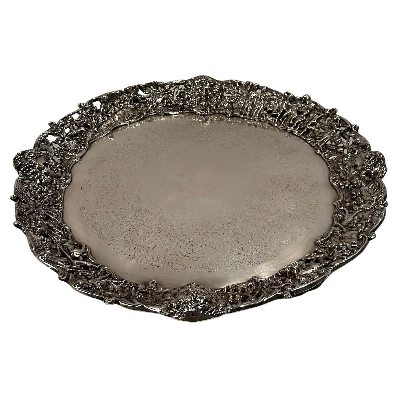 Magnífica bandeja redonda ornamentada de plata con escena de caza en venta