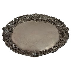 Magnífica bandeja redonda ornamentada de plata con escena de caza