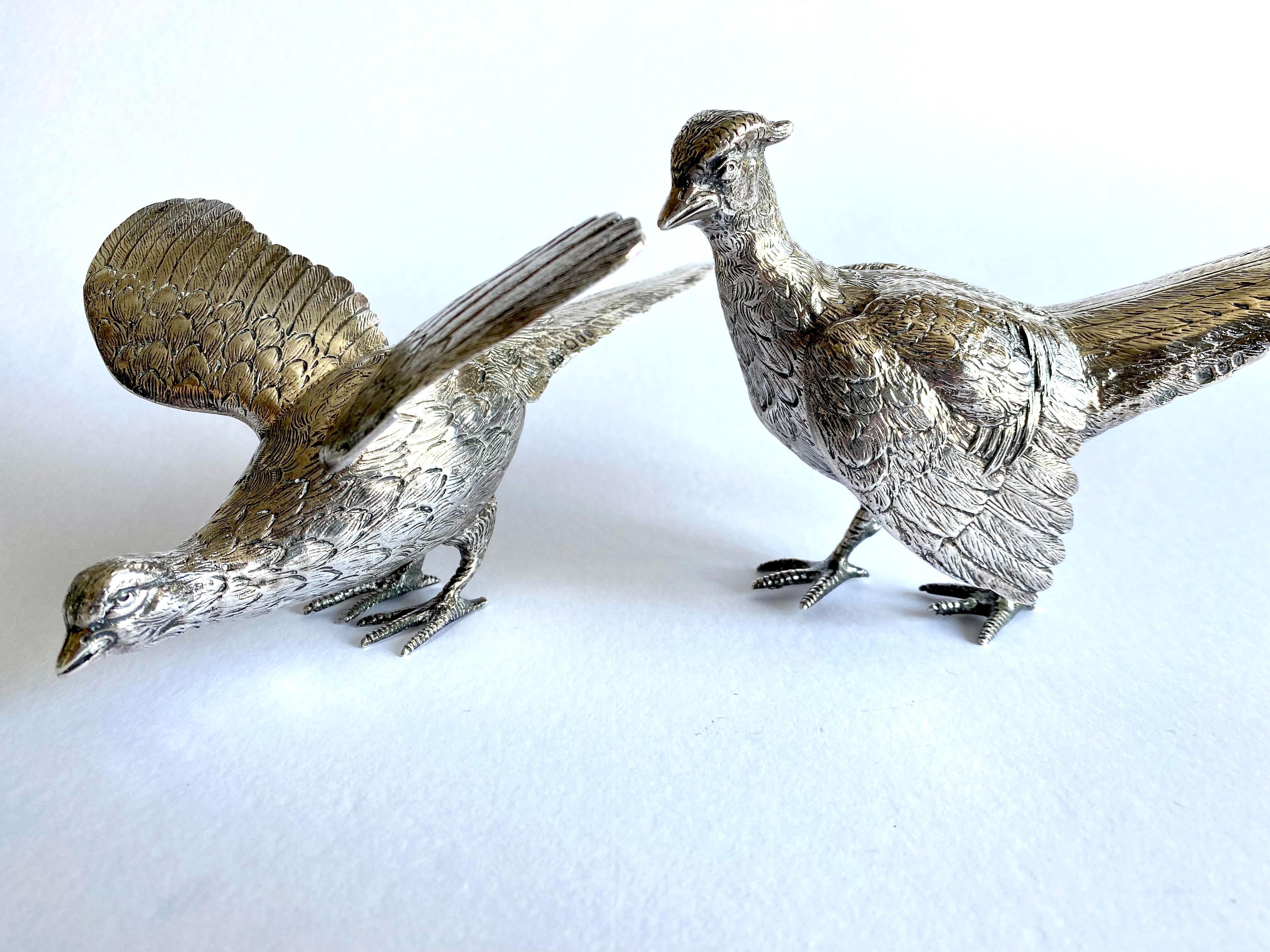 A very handsome Sterling Silver pair of cast pheasants, showing a male and female bird in realistic traditional poses, finely detailed with hand-chased bodies and tail feathers.
In excellent condition.

Hallmarked for London 1968
Silversmith