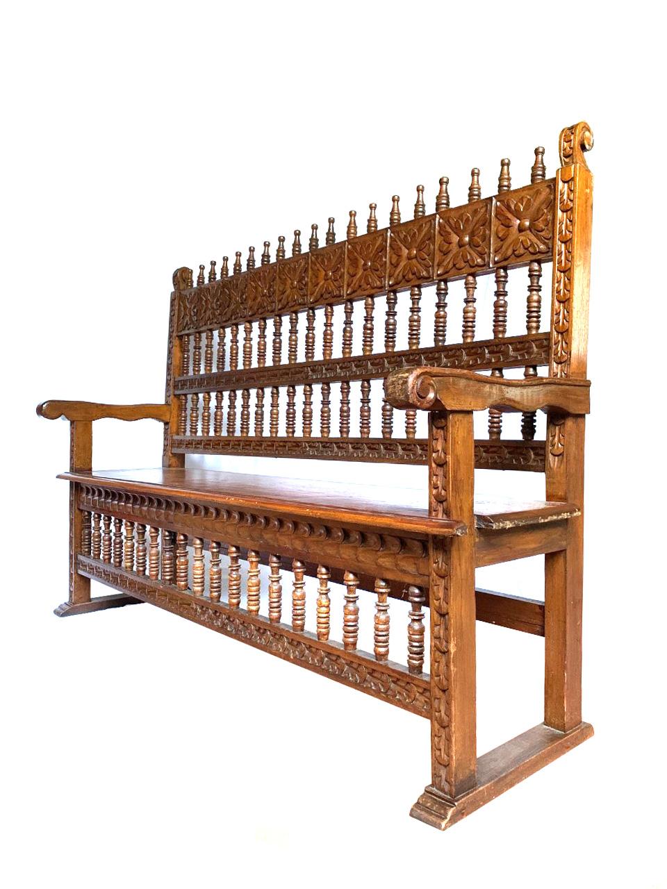 Elevate your space with this magnificent Spanish Colonial Revival bench, a striking example of craftsmanship from circa 1930, originating from Peru. This remarkable piece embodies the rich heritage and intricate design associated with the Colonial