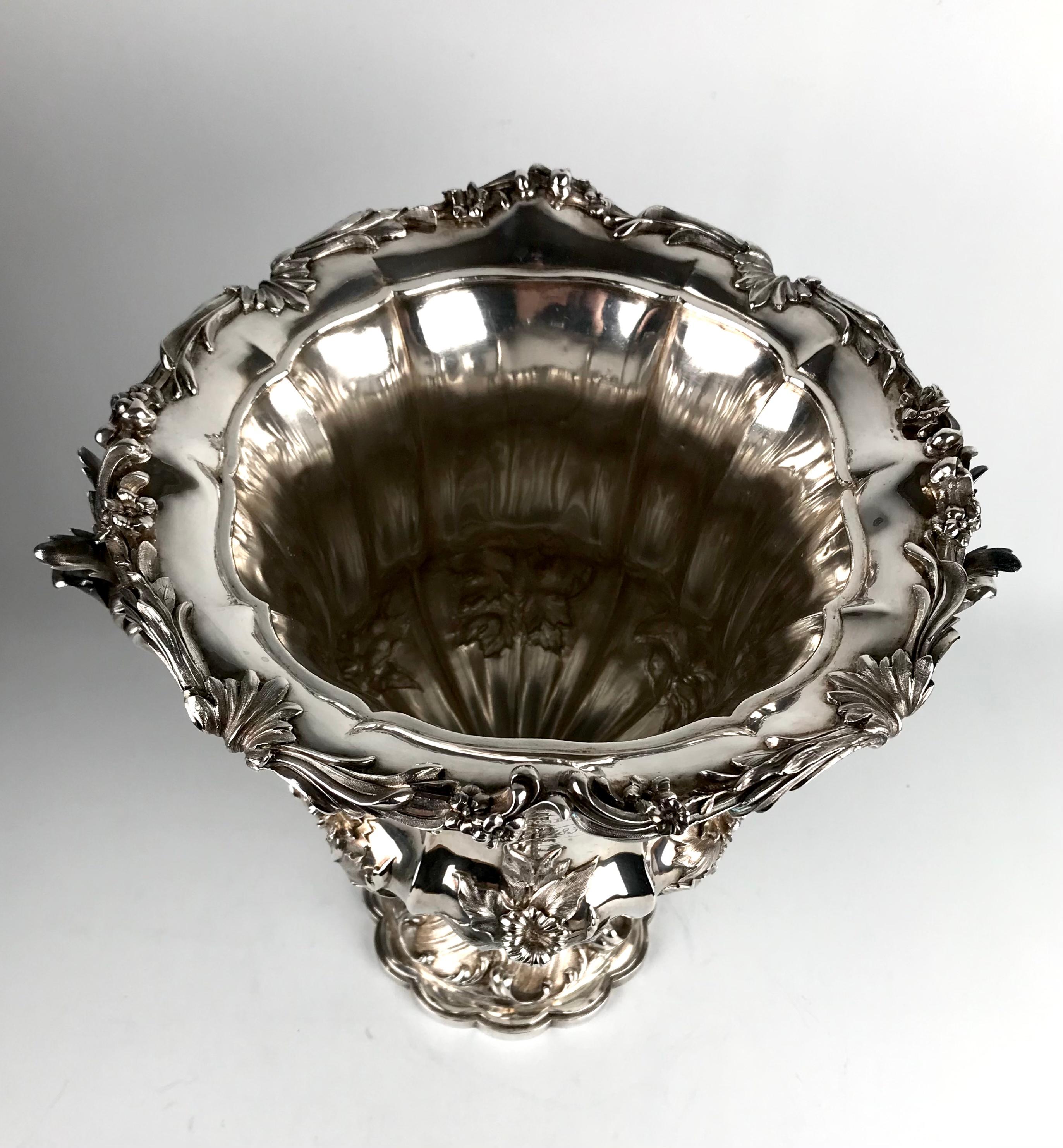 A magnificent solid silver wine cooler with wonderful hammered detailing of acanthus leaves and flowers.
The scalloped base rises up on acanthus leaves to a knop of flowers and leaves, ribbed body agin with floral motifs to a garland rim of leaves