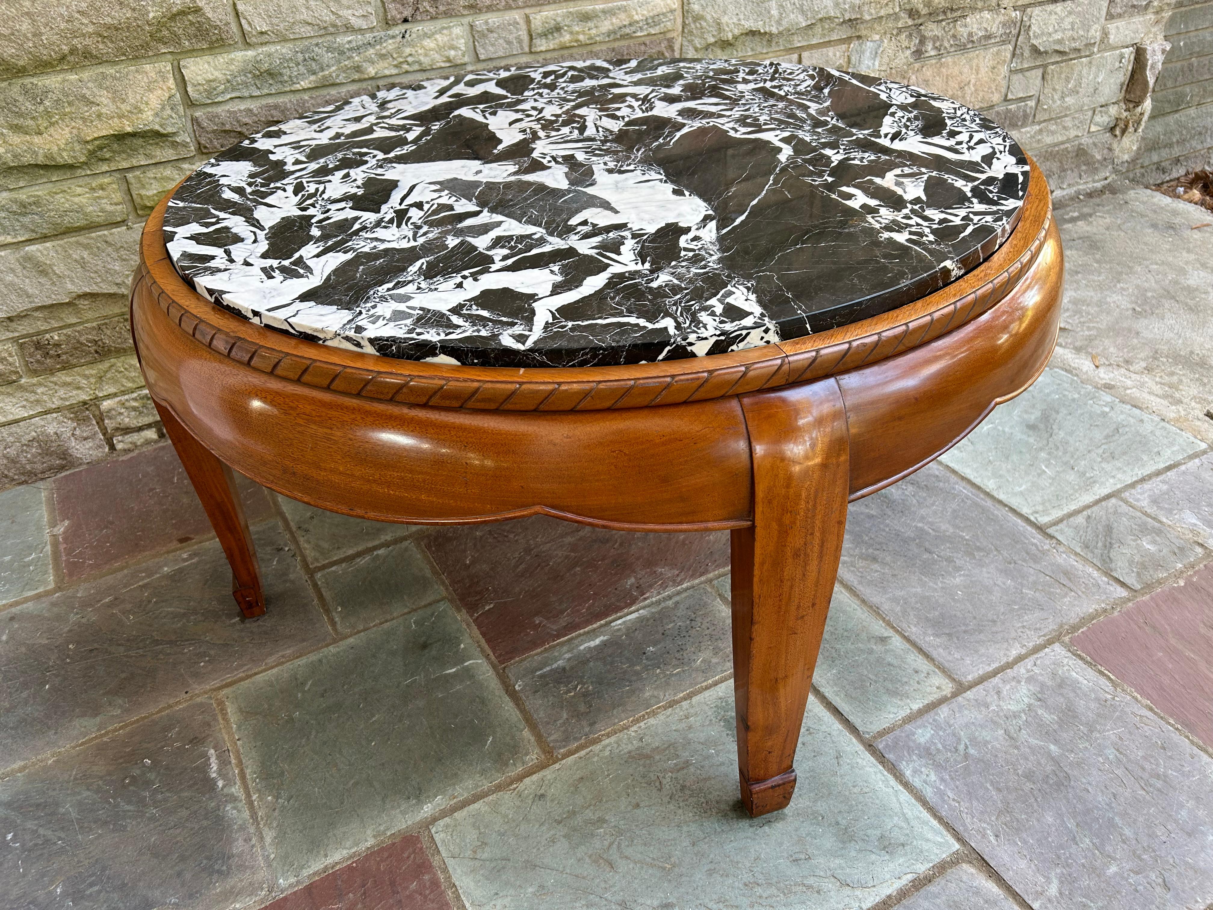 Magnifique table basse de Louis Sue & André Mare, en bois d'acajou sculpté et orné d'un spectaculaire plateau de marbre noir et blanc.   Cette table mesure 21,5 