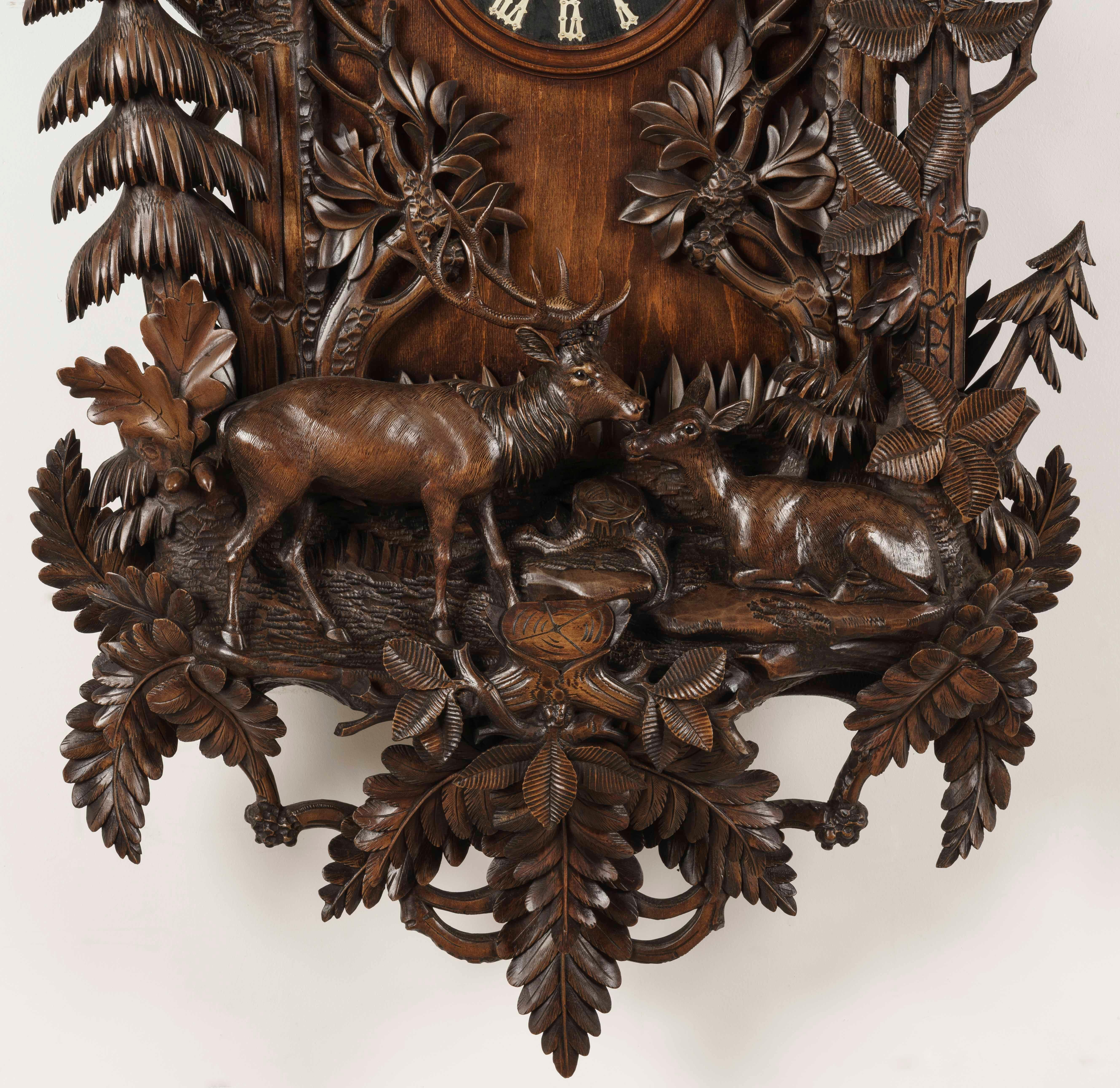 A Magnificent Black Forest wall clock

The Lindenwood case of grand proportions--nearly 6 feet tall-- and well carved with realistic deer and a perched bird within a wooded landscape, all amongst a branched garland of oak leaves; the weight-driven
