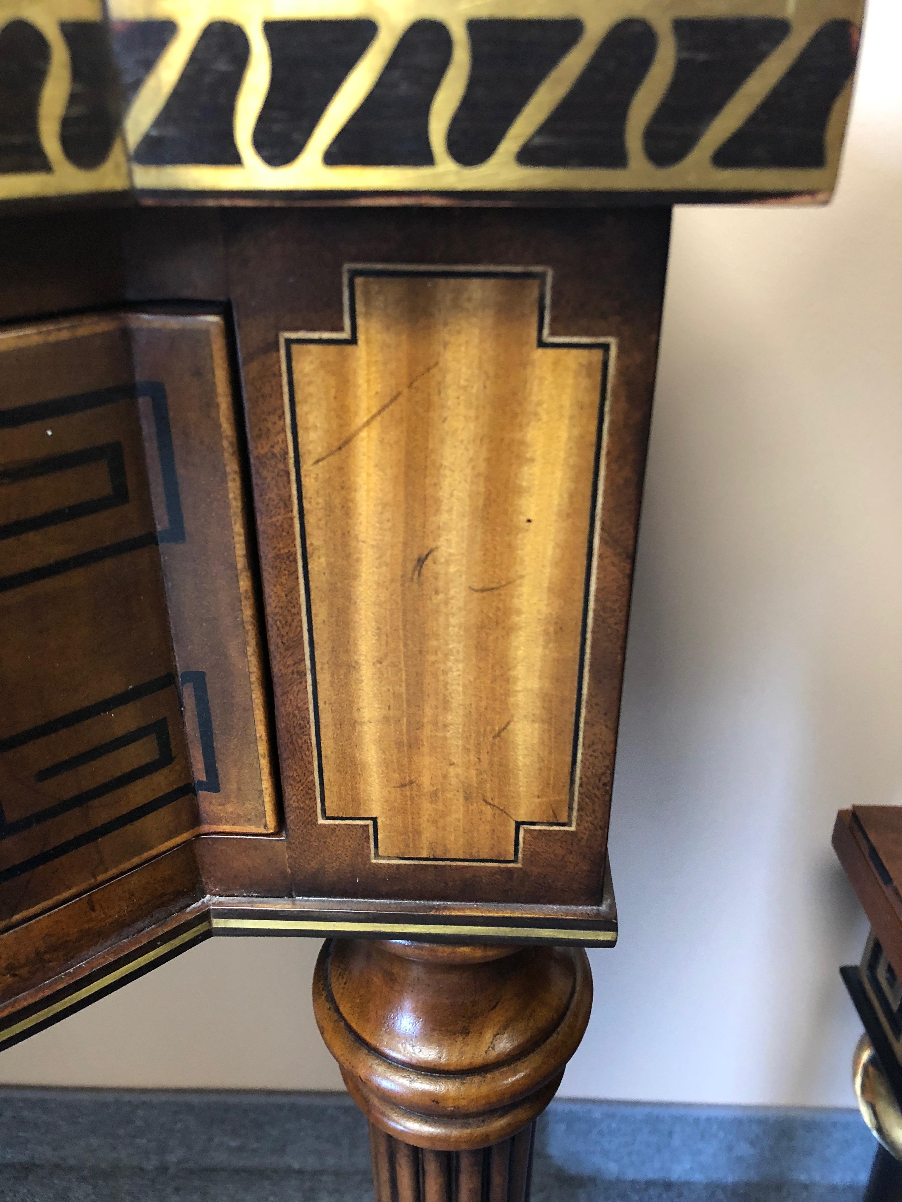 A very impressive large mahogany console table by Theodore Alexander having stunning satinwood and ebony inlay and a special touch of brass decorative inlay around the front curved edges and sides. There is also neoclassical ebony Greek key
