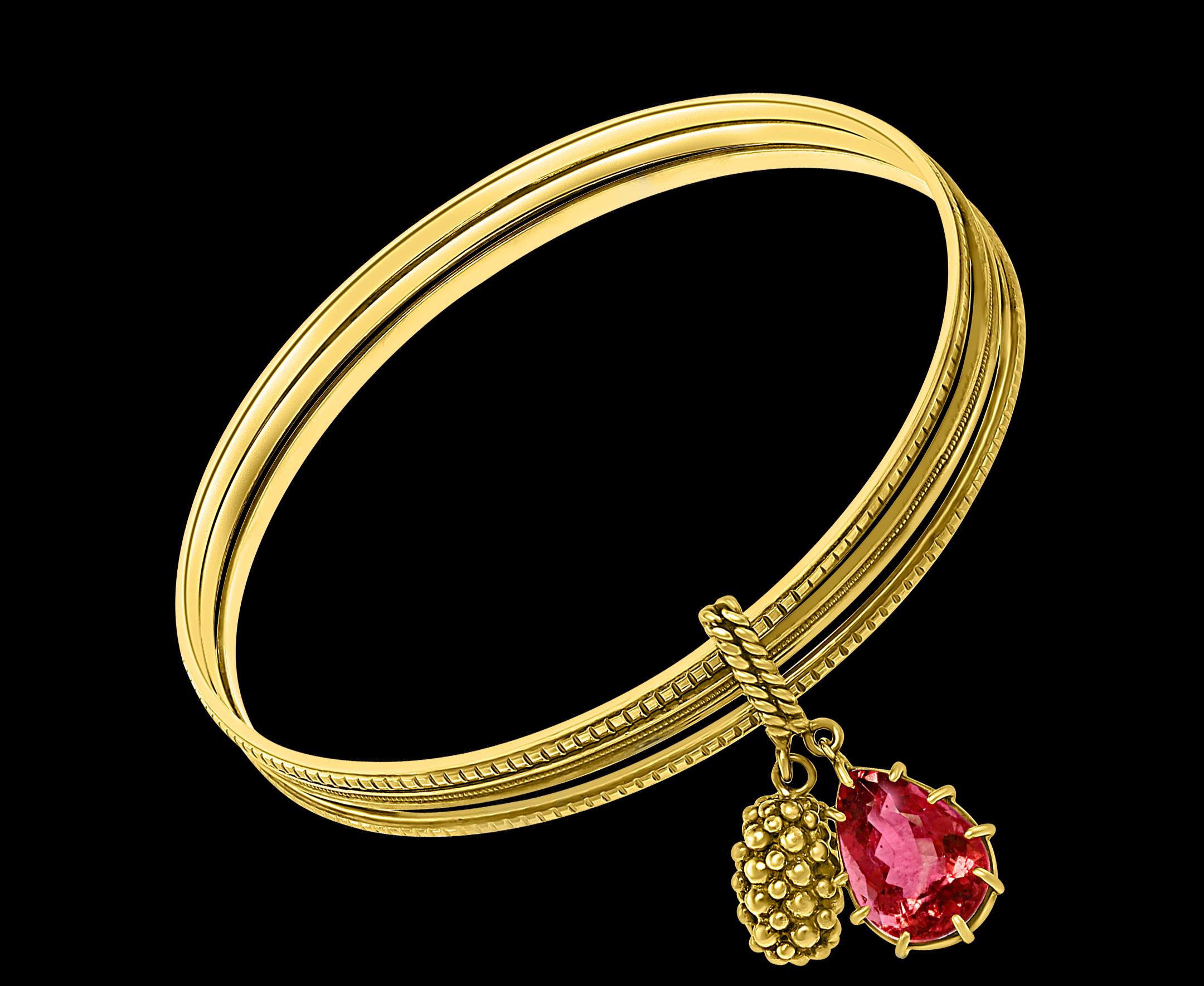 Magnificent Three Yellow Gold Bangle Attached by Pink Tourmaline & Gold Charm in 18 K Gold

This  iconic and timeless  Bangle bracelet  is finely crafted in 18 karat  Yellow gold. 
18 K yellow Gold 27 Grams
amazing workmanship.
Natural Pink