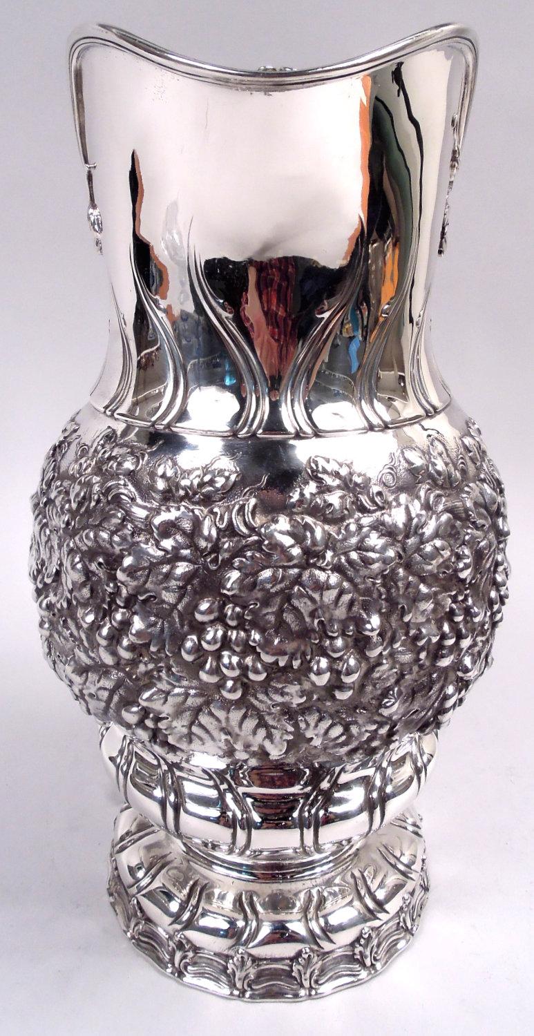 Magnifique cruche à vin en argent sterling de style classique victorien. Fabriqué par Tiffany & Co. à New York. Coupe globulaire sur pied bombé et pied en dôme ; bouche en forme de casque et anse en forme de boucle haute. Vigne dense à fruits