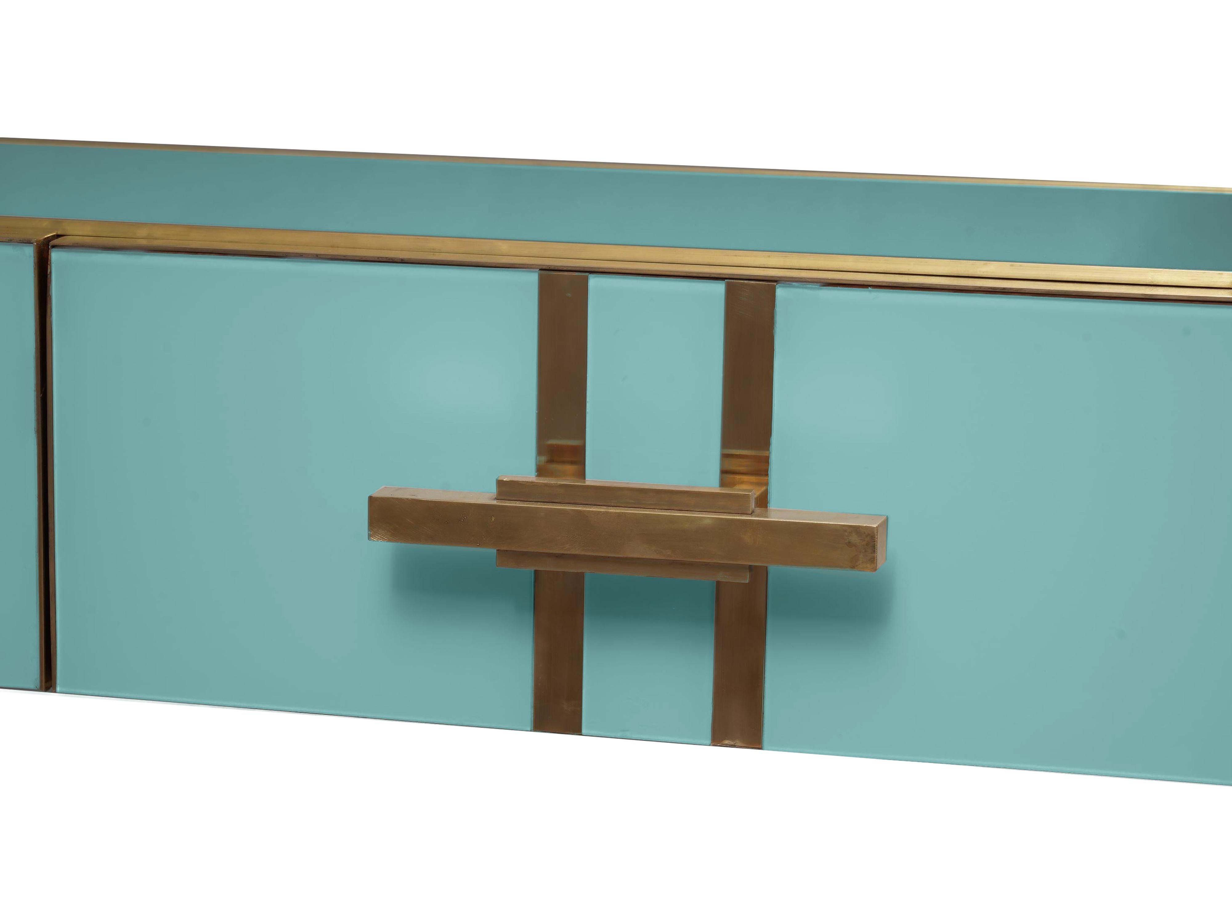 Introducing the magnificent turquoise Murano glass console table with brass legs, a masterpiece of Italian craftsmanship that brings the elegance and sophistication of Mid-Century modern design to your living room. 

This unique console table is a