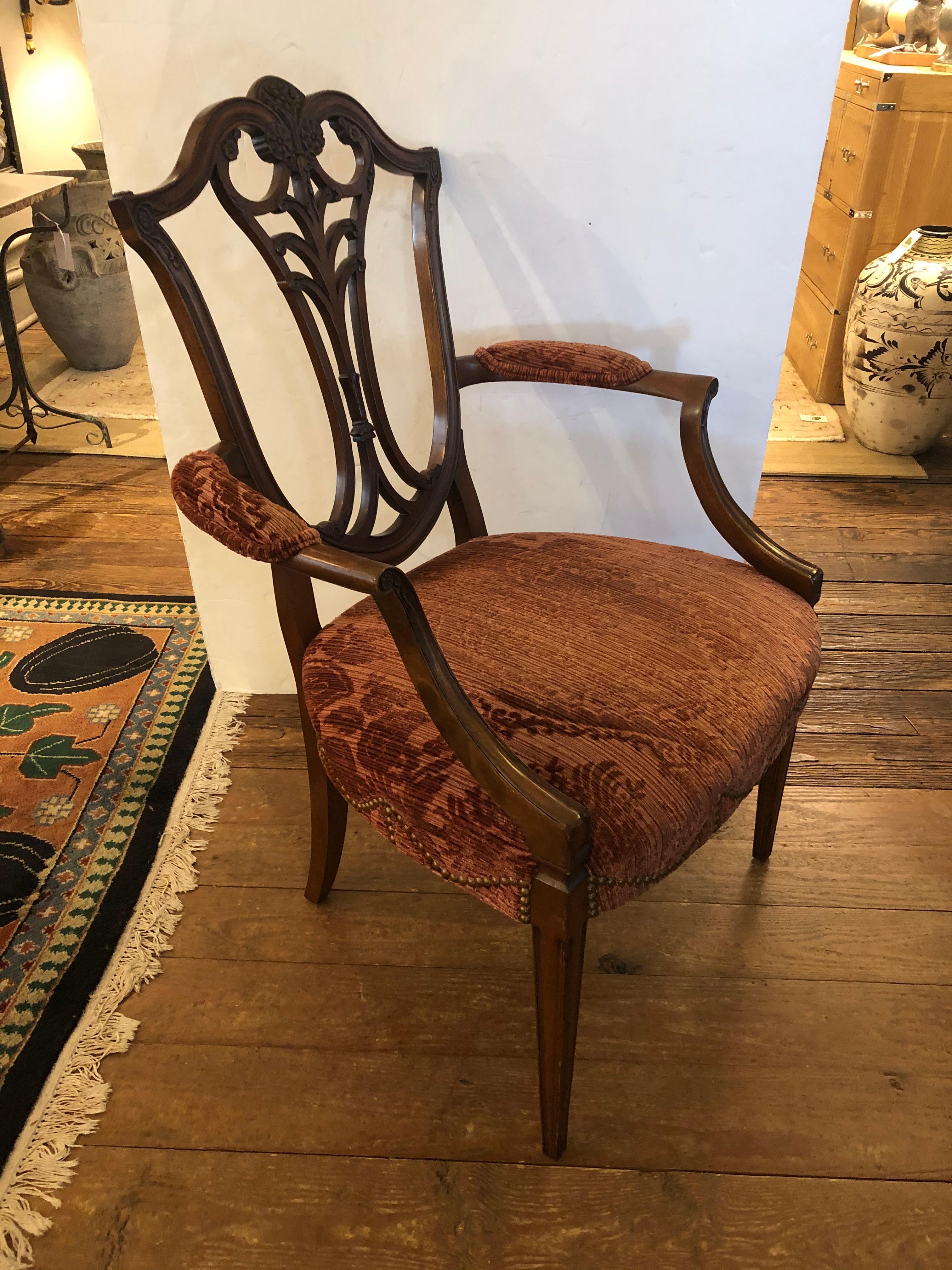 A show stealer elegant armchair for use in the livingroom or at a fancy desk having carved mahogany shield back and curved arms with upholstered arm rests. The seat is upholstered in a sumptuous soft rust colored cut velvet.
Measures: Seat width