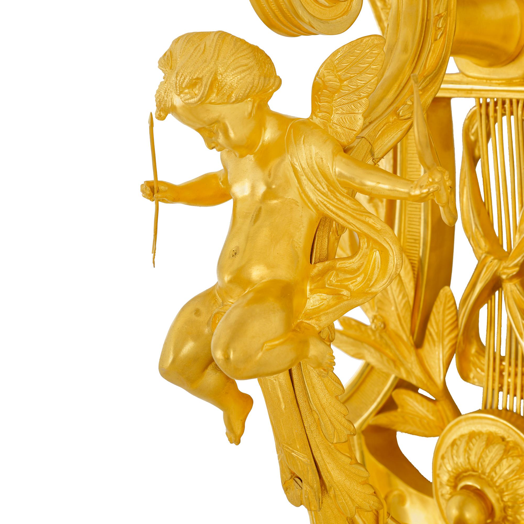 The wall sconce is made of intricately chiseled brass plated with 24-carat gold, featuring natural elements such as olive branches and an angel holding a torch that lights the candleholders. This wall lamp is a luxurious piece, handcrafted by