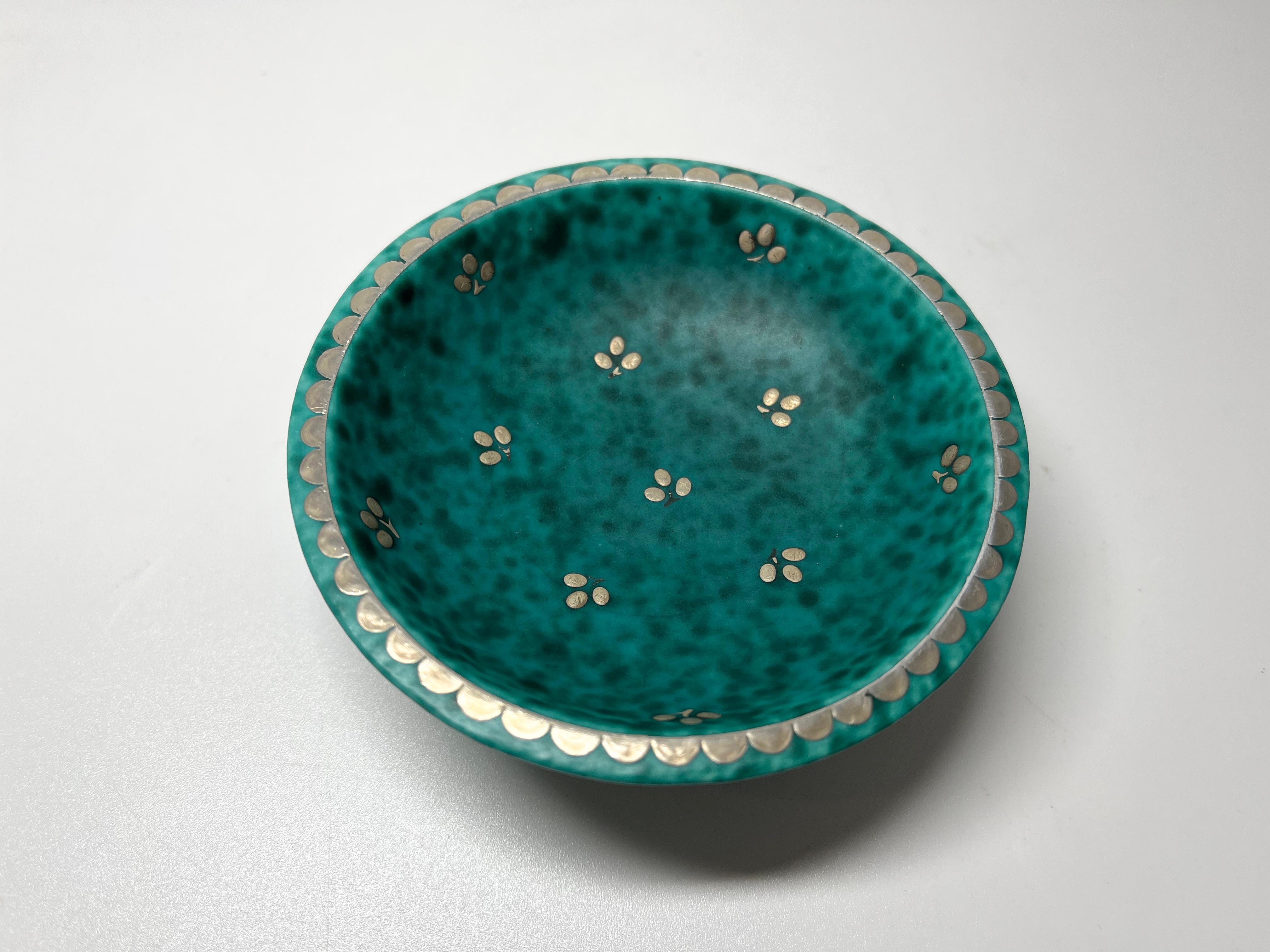 Small footed stoneware Argenta dish by Wilhelm Kage for Gustavsberg, Sweden. Decorated with trefoil flower sprigs and banding to rim and foot in applied silver
A lovely 'introduction to Argenta' piece
Circa 1960's
Stamped Gustavsberg Argenta on